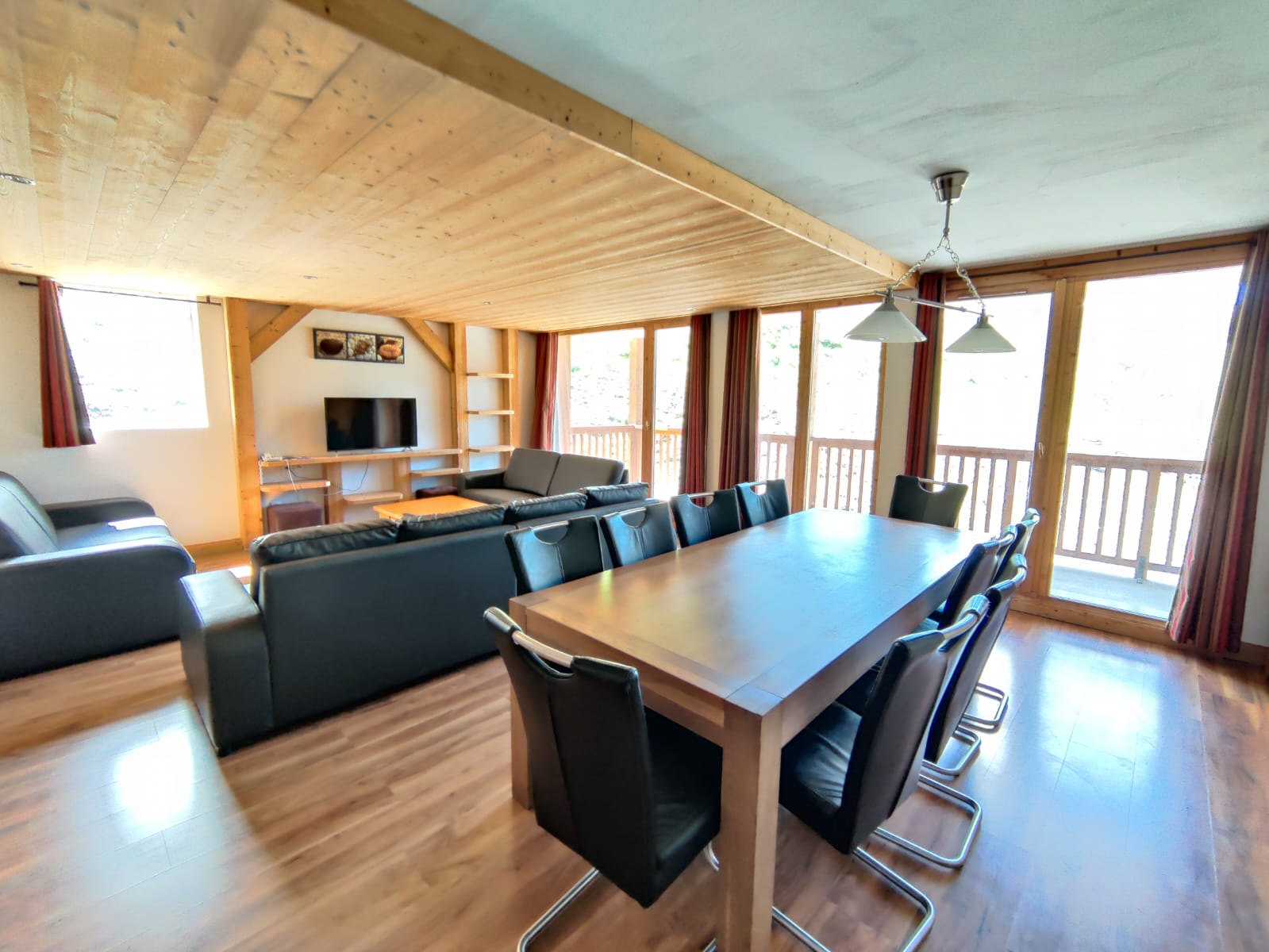 image Spacious living and dining area with leather sofas and a large wooden dining table.