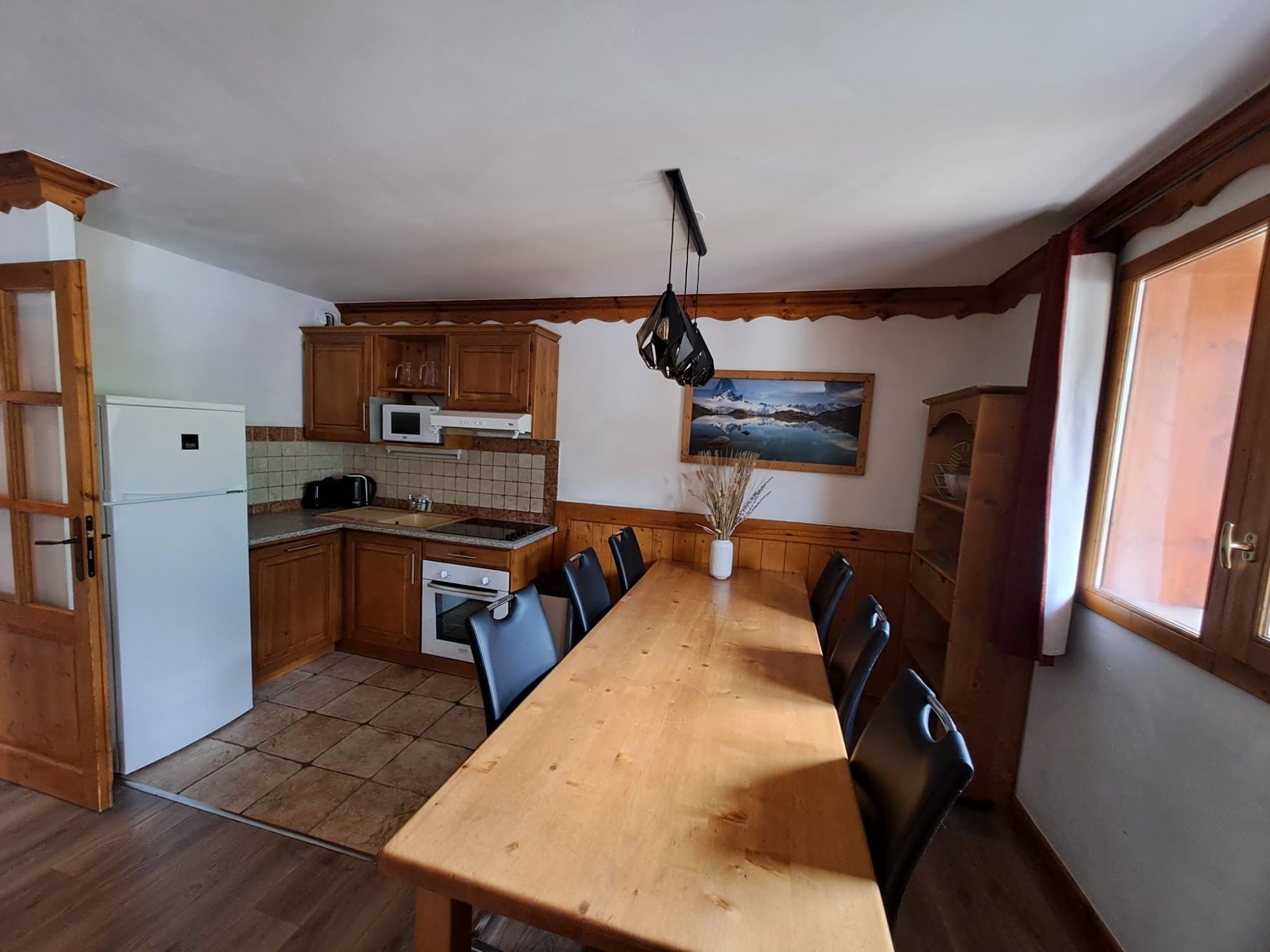 image Kitchen and dining area with wooden cabinets and table