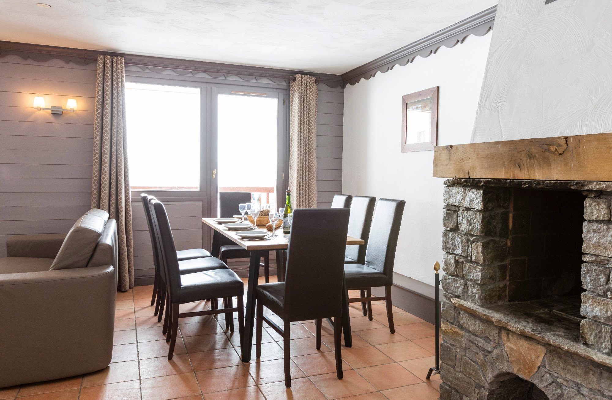 image Gather around the dining table with the fireplace close by.