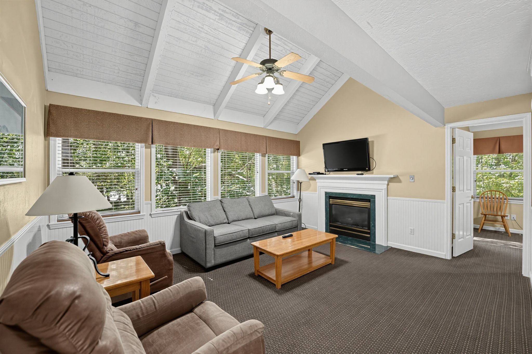 image Living room with sofa, armchair, and windows with shades