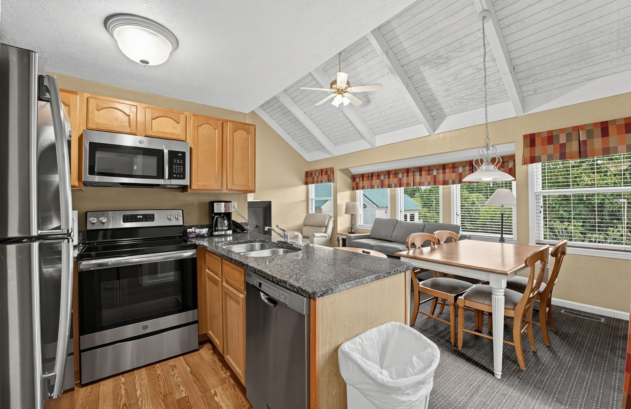 image Kitchen with a dishwasher and breakfast bar, opening to the dining table and living area.