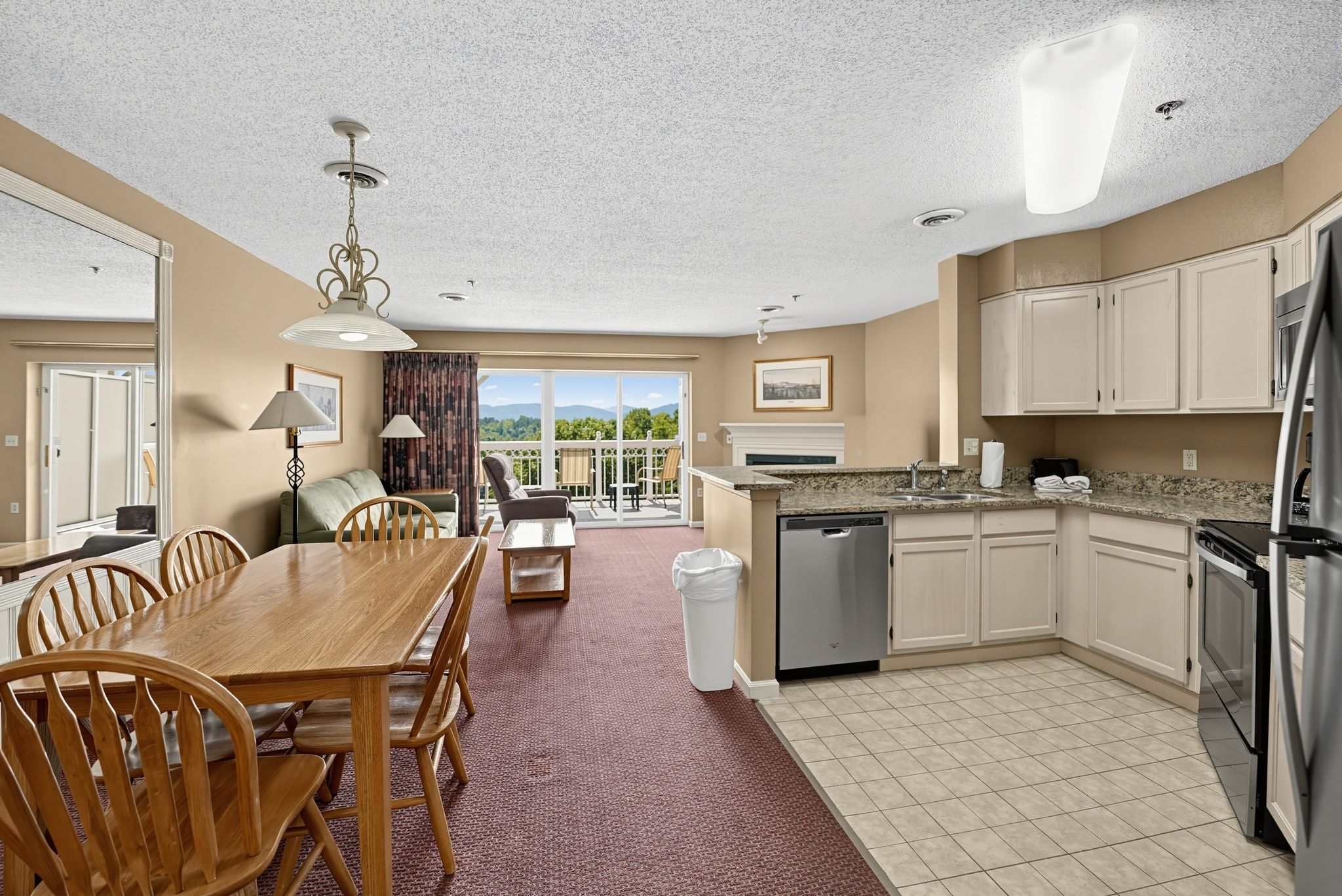image Dining table and open kitchen beside the living area and the balcony doors.
