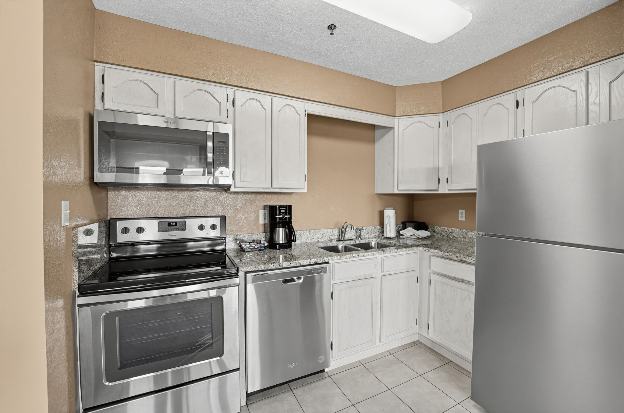 image Kitchen with a stainless steel refrigerator, range, dishwasher, and microwave.