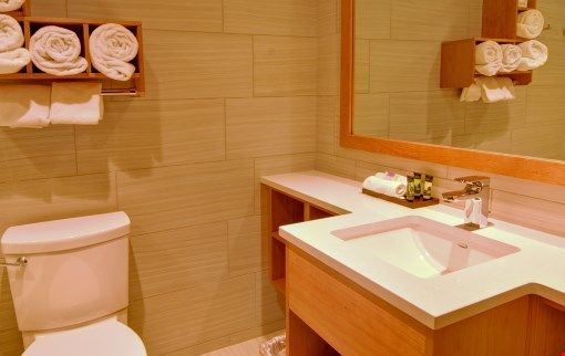 image Prepare for your day outside in the spacious bathroom featuring warm wood touches.