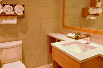 Prepare for your day outside in the spacious bathroom featuring warm wood touches.