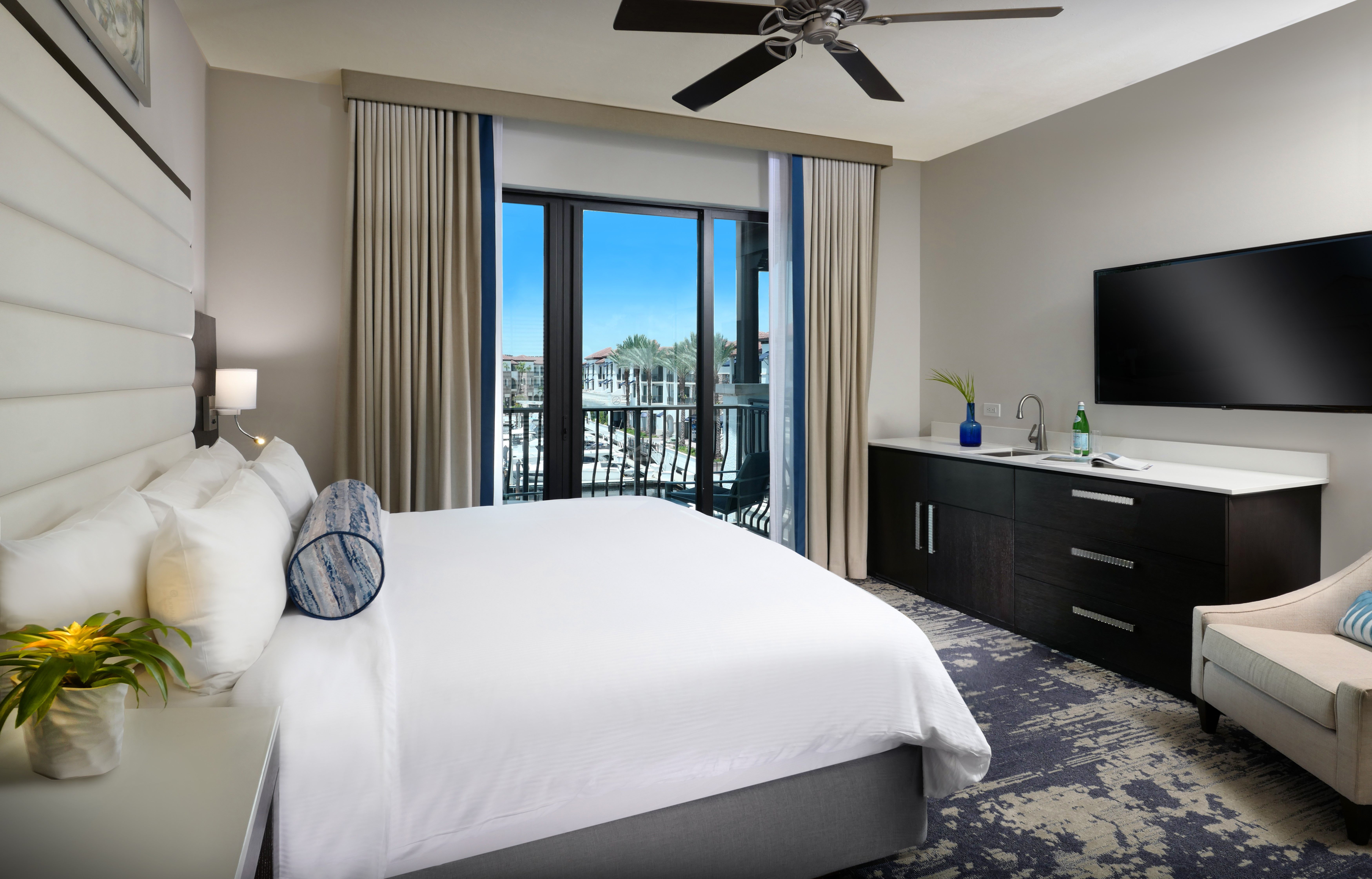 image Bedroom with king-size bed, ceiling fan, and wall-mounted TV