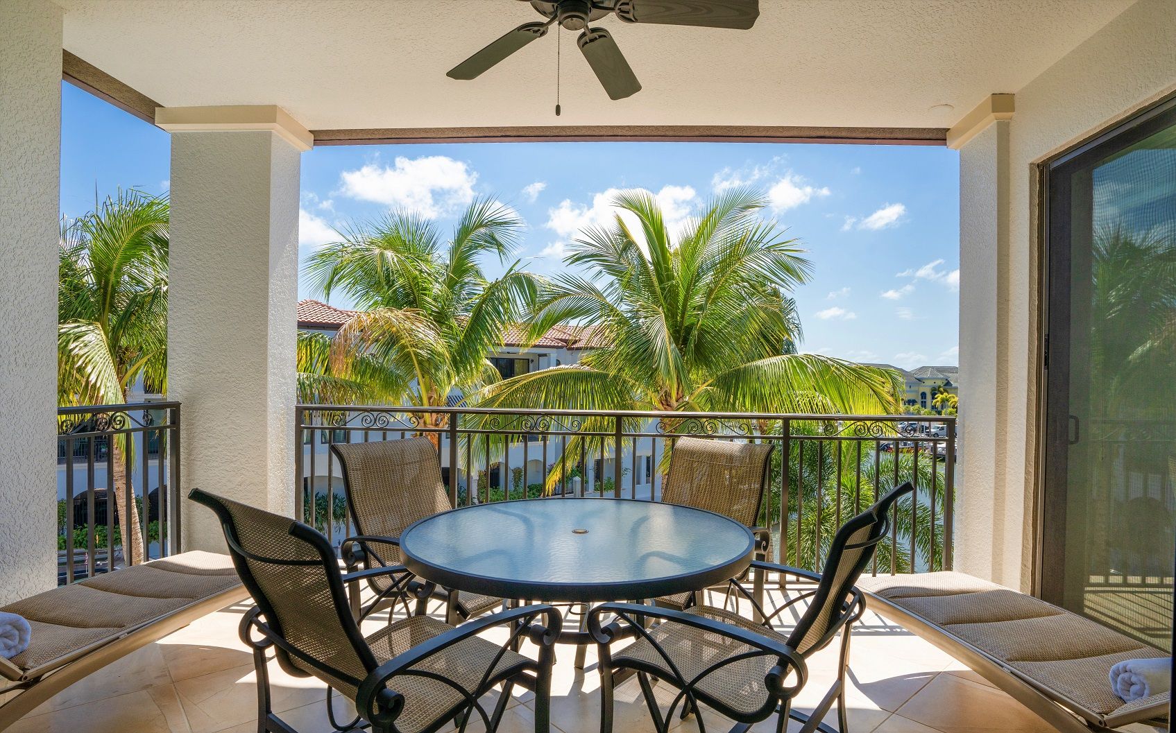 image Furnished balcony with seating, ceiling fan, and marina views