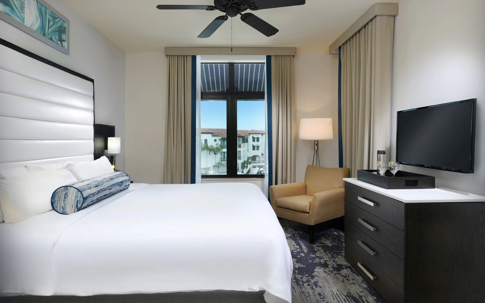 image Bedroom with king-size bed, ceiling fan, and wall-mounted TV