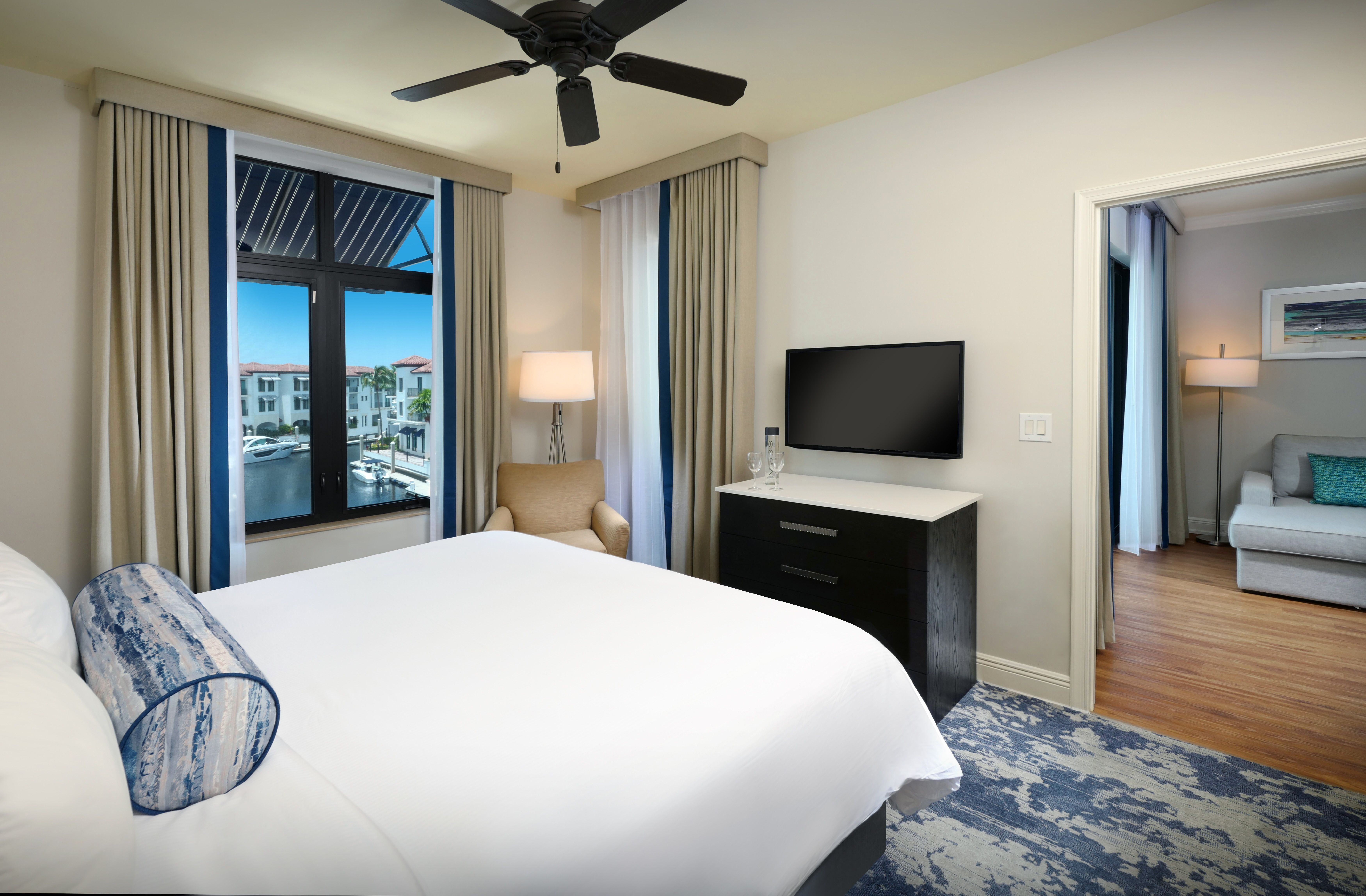 image Bedroom with king-size bed, ceiling fan, and wall-mounted TV