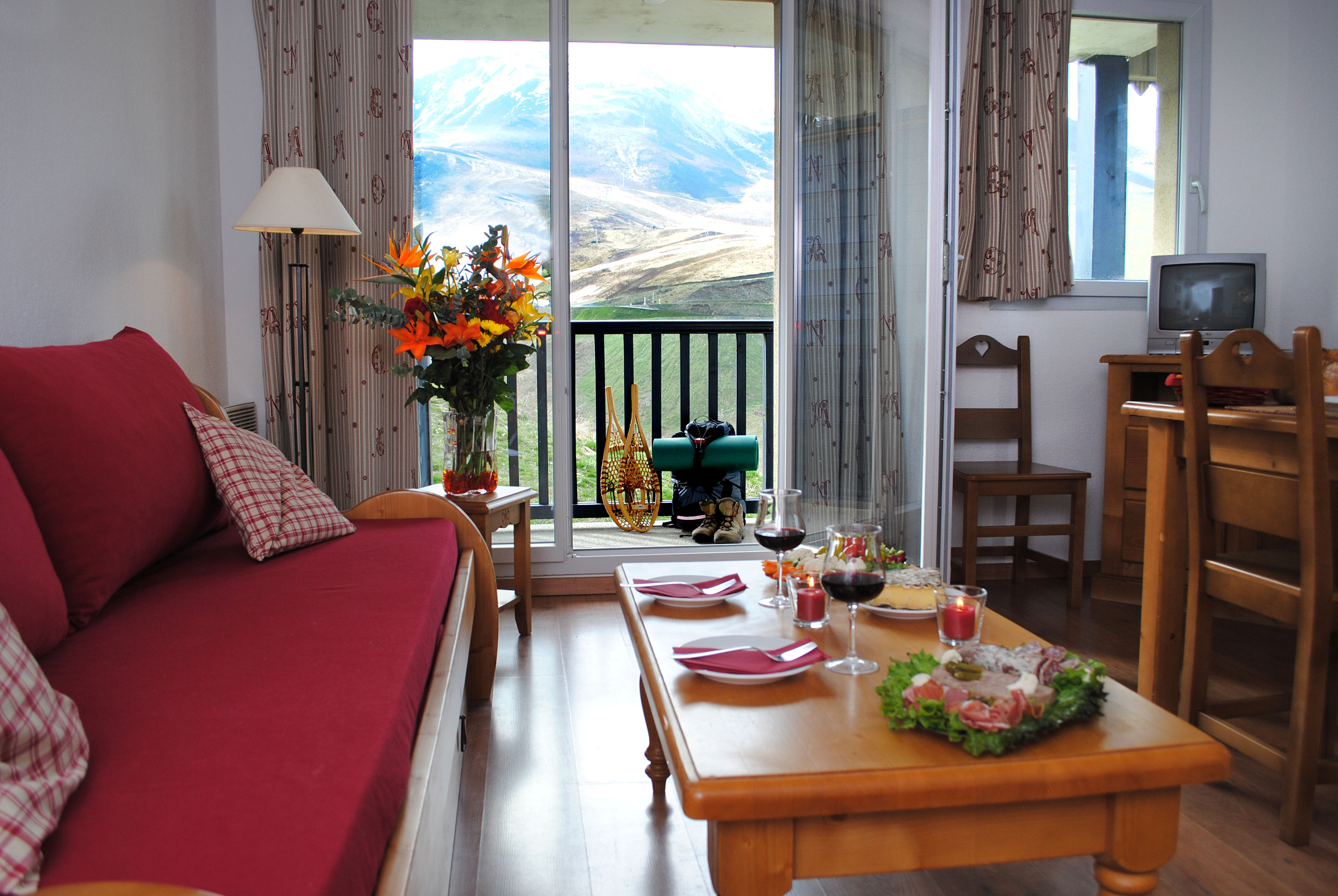image Living area with flowers, TV, and mountain views through sliding glass door
