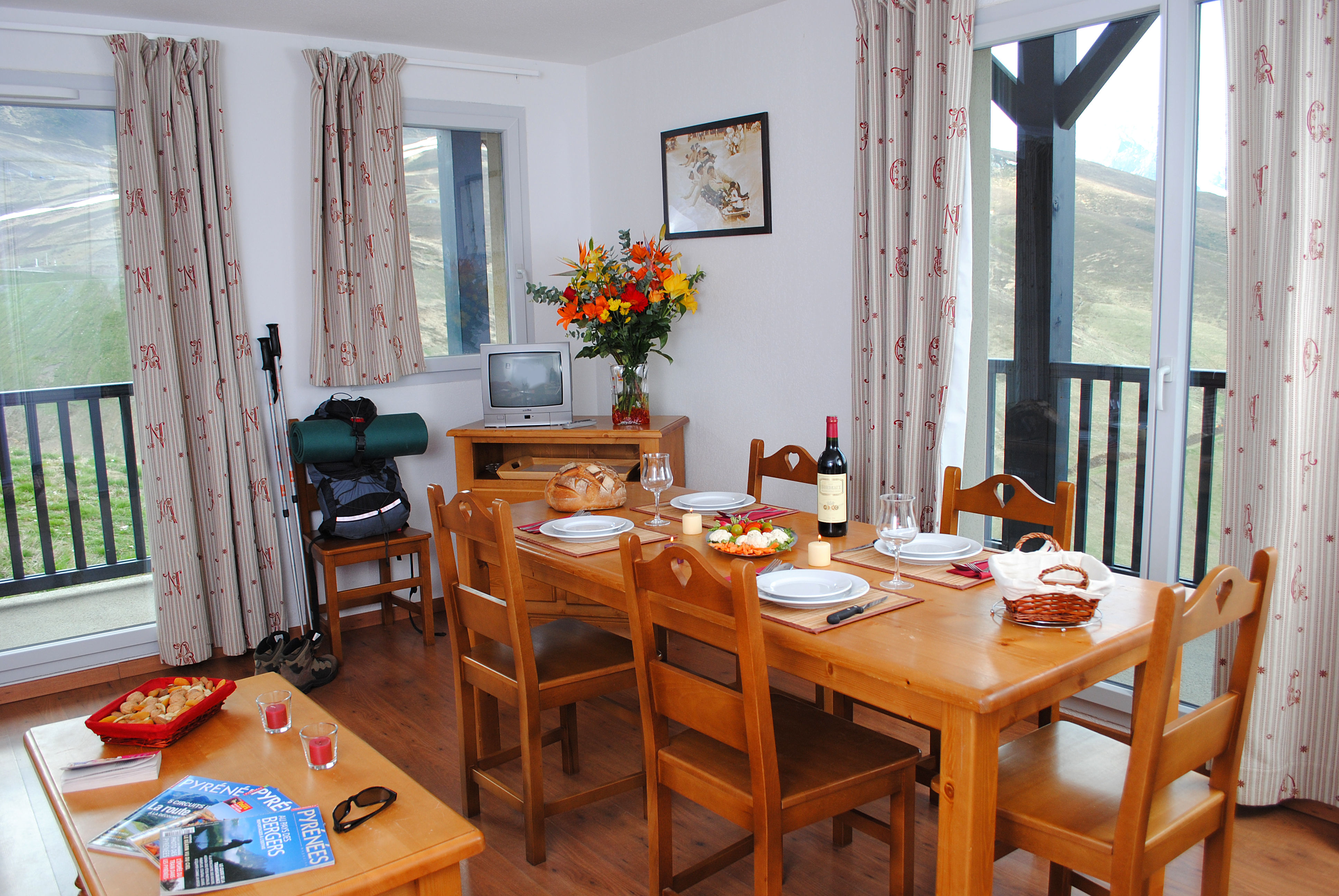 image Dining area with a wooden table set for a meal and a television