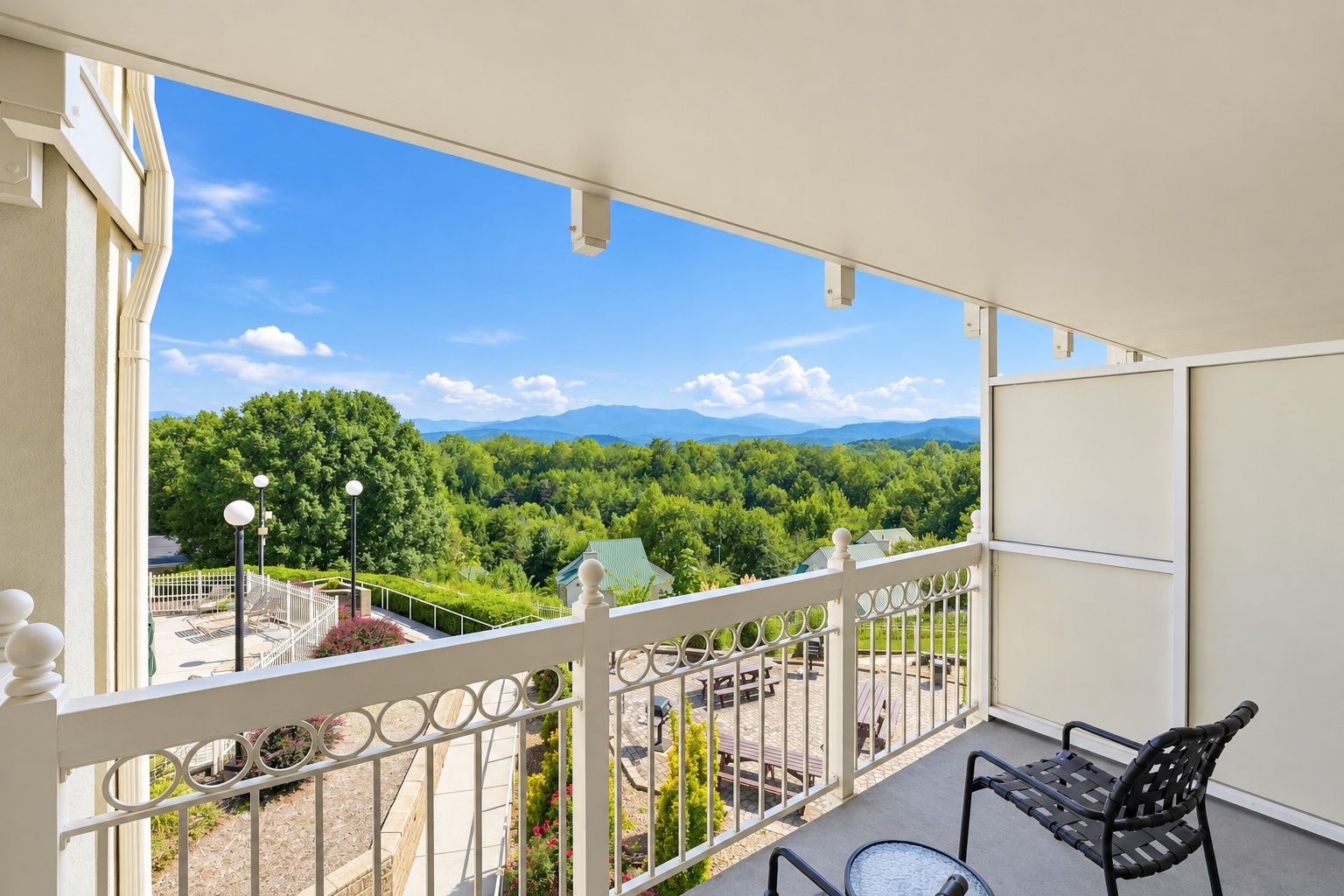 image Balcony with a patio chair and a view of green hills and distant mountains.