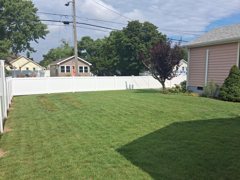 image Fenced grass backyard with white vinyl fence