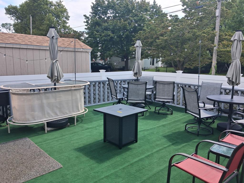 image Open deck with artificial turf, fire pit table, bar and patio seating
