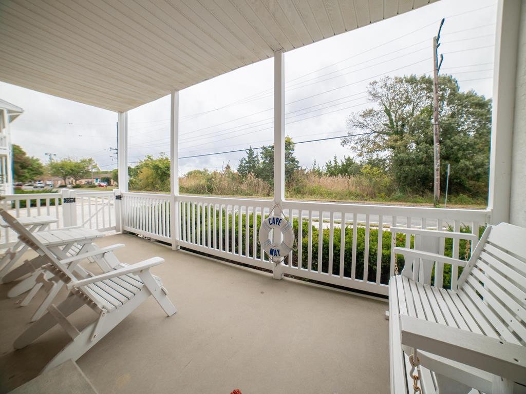 image Covered porch with chairs, porch swing and white railing