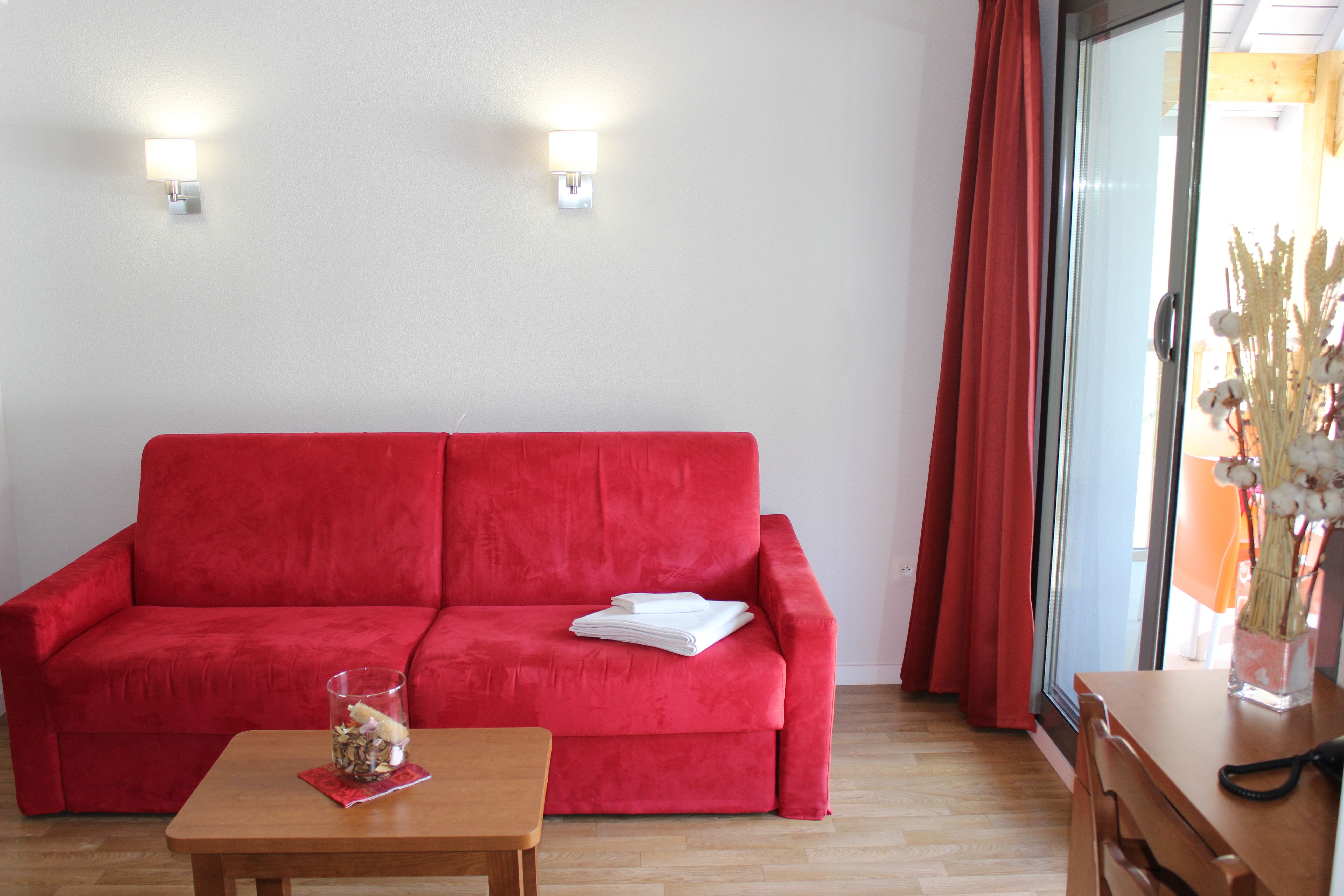 image Bright and inviting living space opening onto a balcony made for morning coffee.