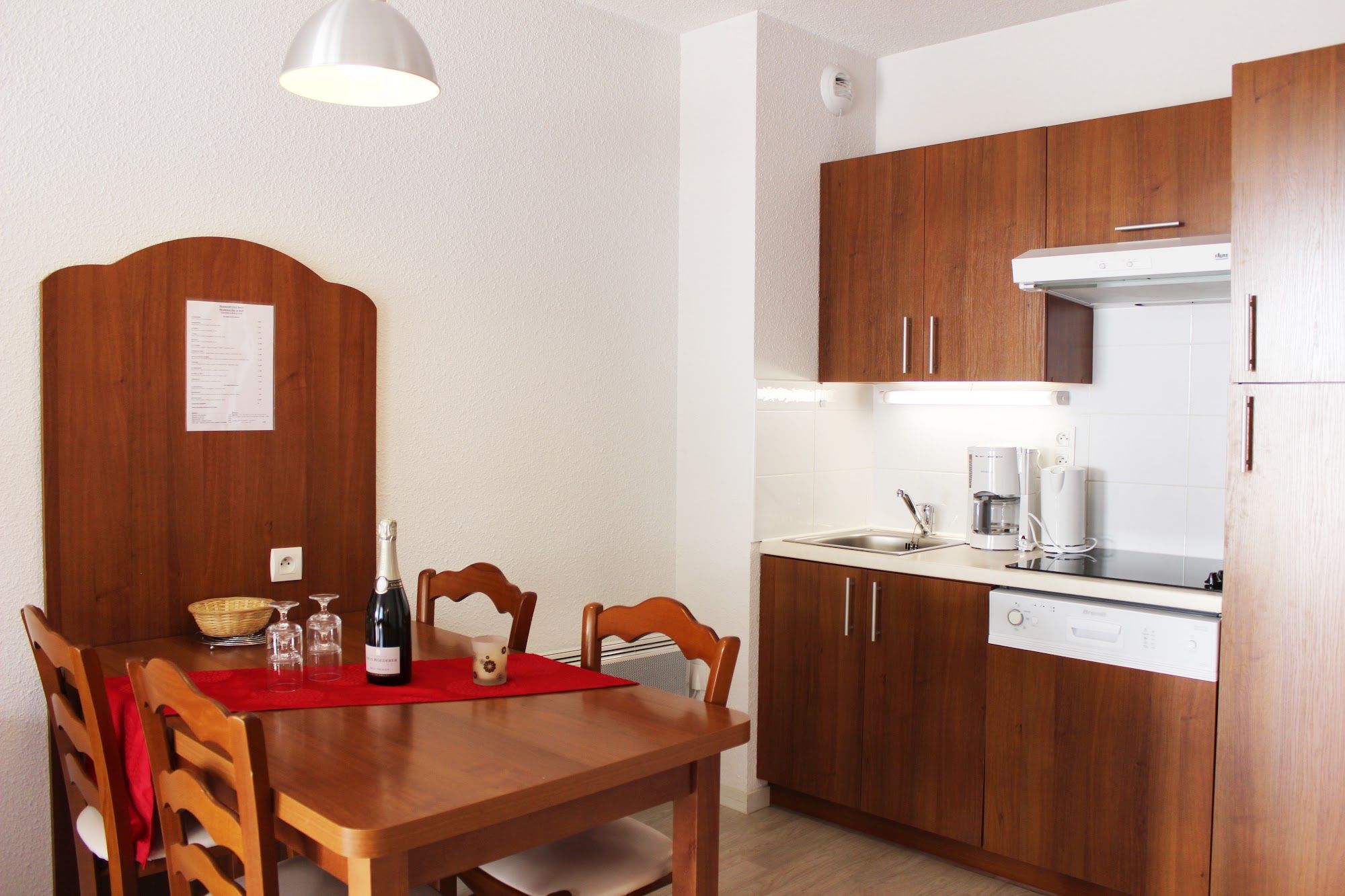 image Wooden dining table set for a relaxed meal with the kitchen close by.