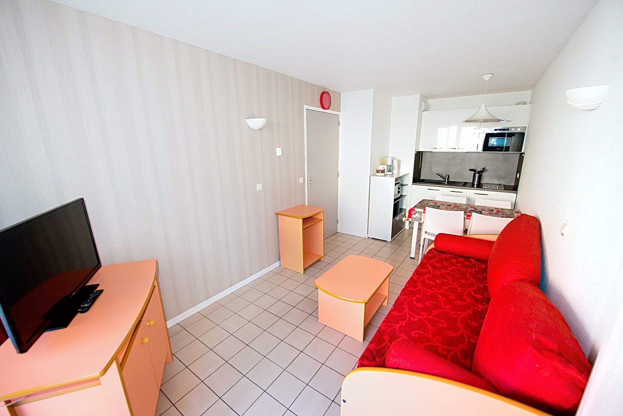 image Red sofa and orange furniture beside the kitchenette, made for slow spa-break days.