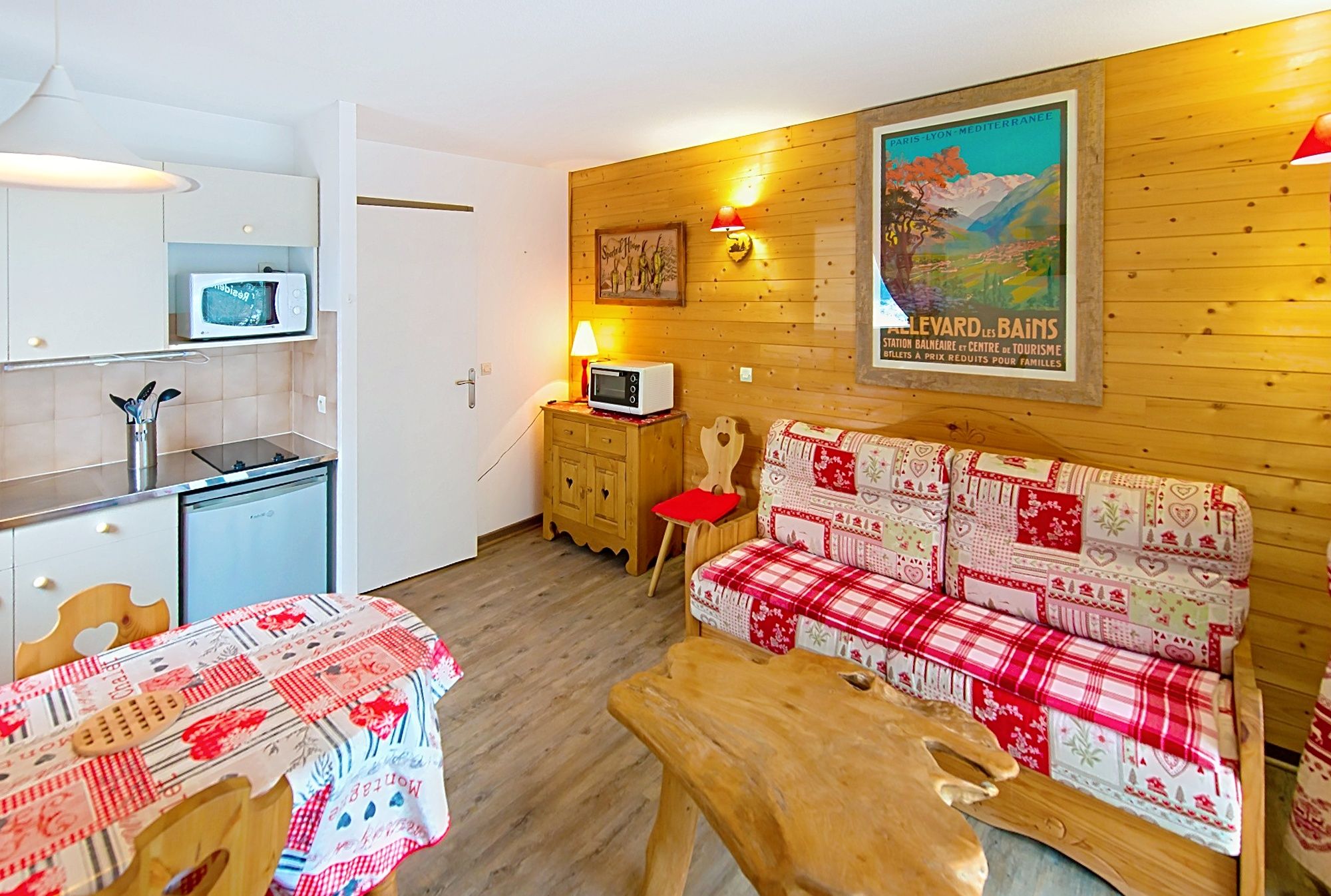 image Dining area with a wooden table and kitchenette, set for a relaxed meal in.