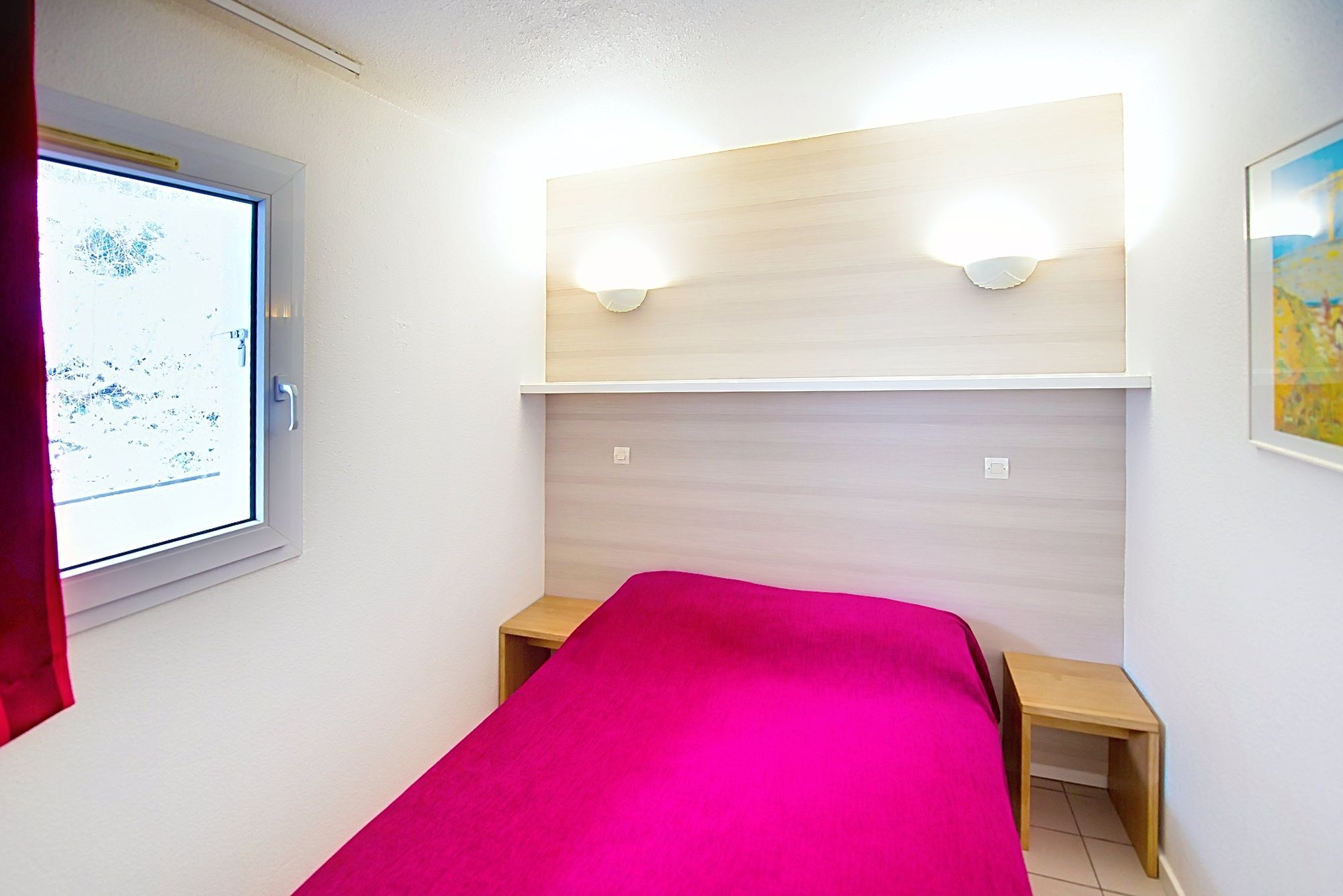 image Bedroom with a pink bedspread and wooden nightstands, set for a restful night.