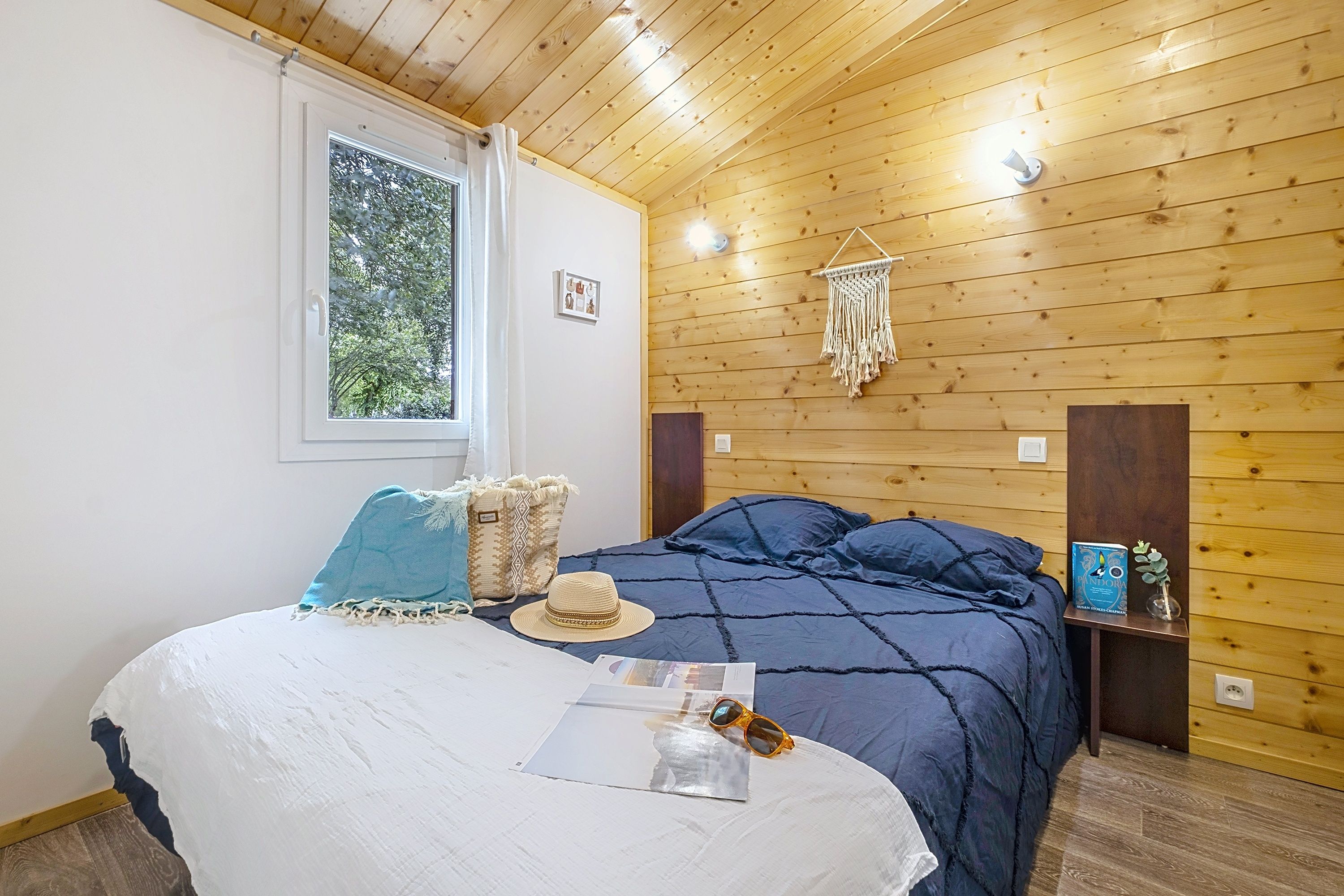 image A sun hat and sunglasses rest on the dark blue bedding, ready for another day by the sea.