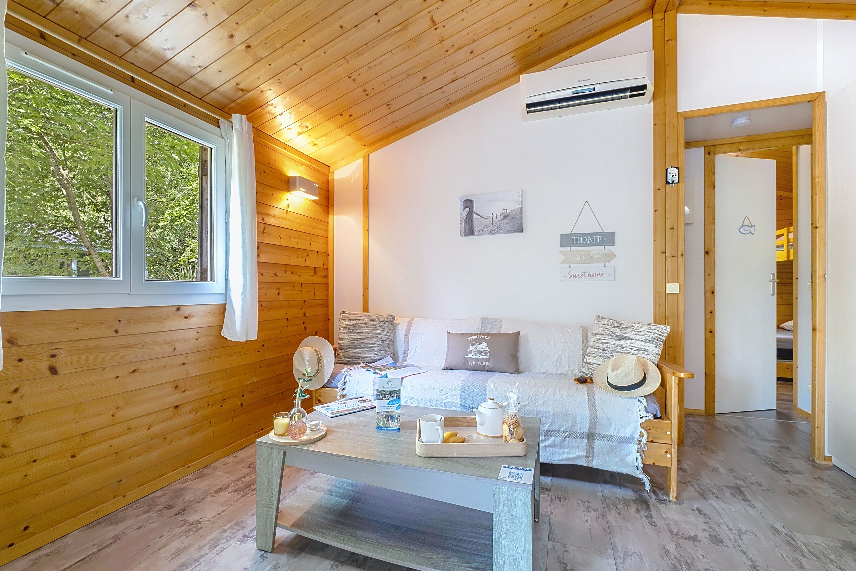 image A white sofa and wooden coffee table face a window onto the greenery outside.