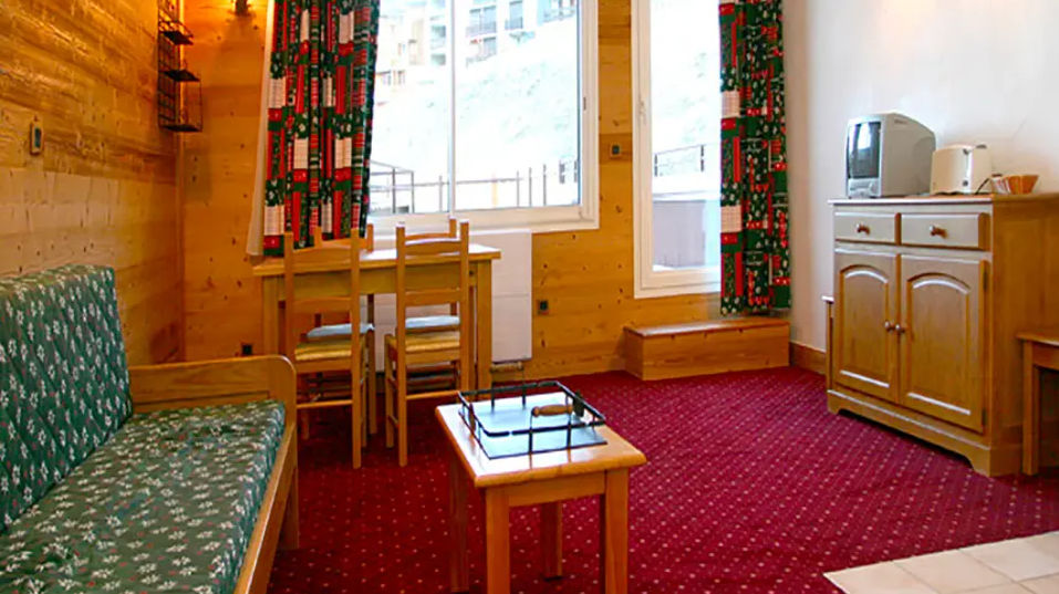 image A sunny dining nook, a cosy sofa and timber-panelled walls make the living room a welcoming spot to regroup after a day on the pistes.