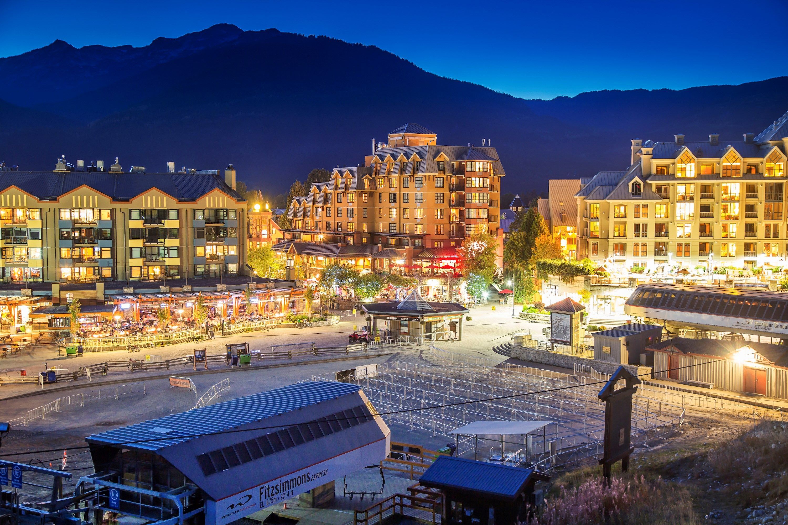 image Twilight casts a warm glow over the lively streets and scenic mountain horizon.