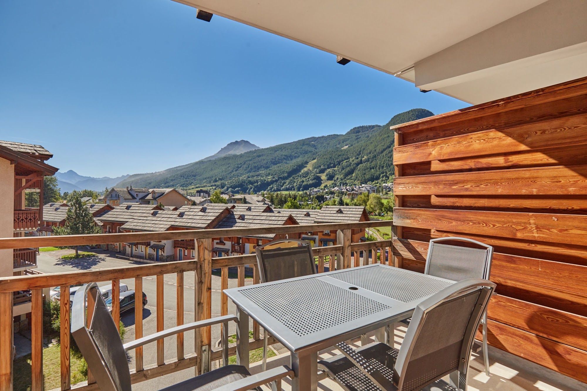 image Balcony with a metal table and chairs overlooking the mountains