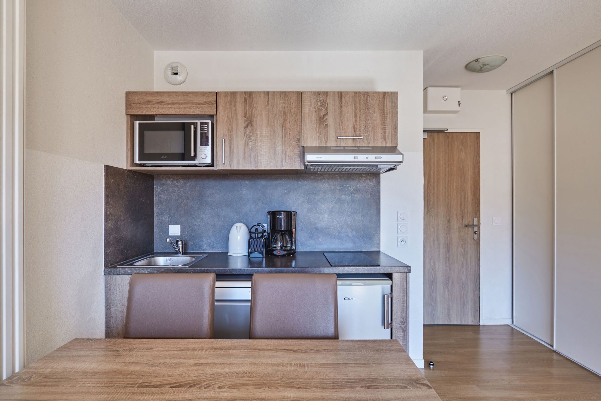 image Kitchenette with a microwave and coffee maker on the counter