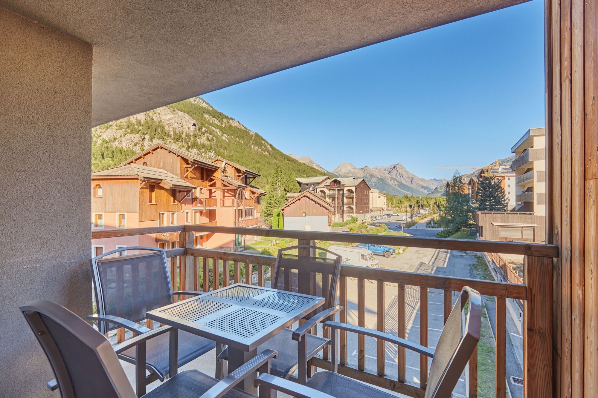 image Balcony view of mountains and nearby buildings under a blue sky