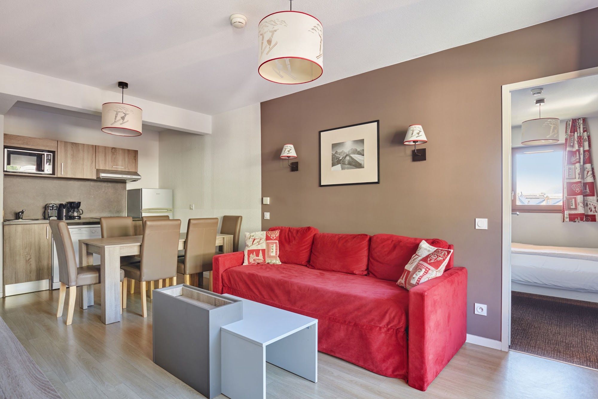 image Living area with a dining table and red sofa