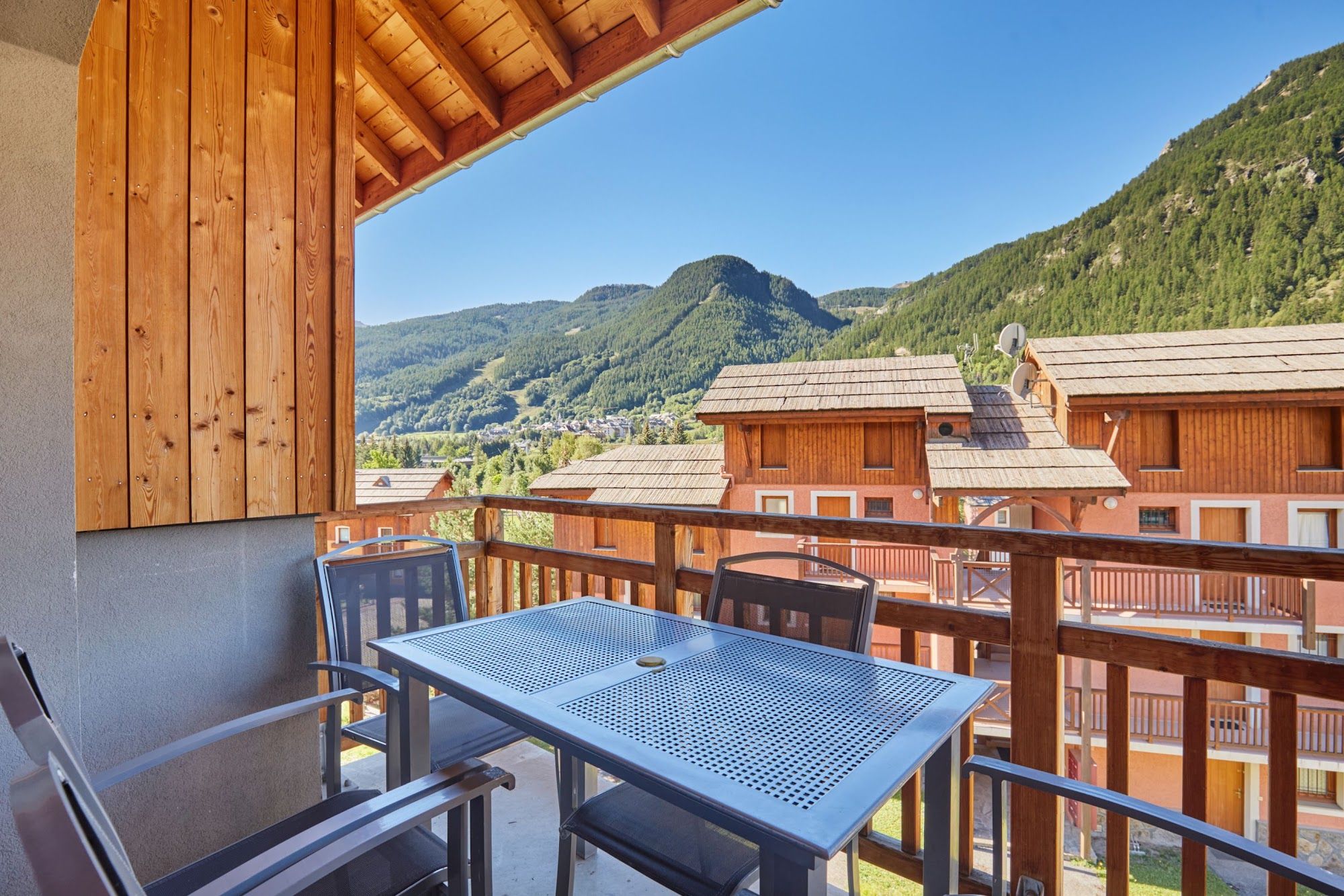 image Balcony with a metal table and chairs overlooking the mountains
