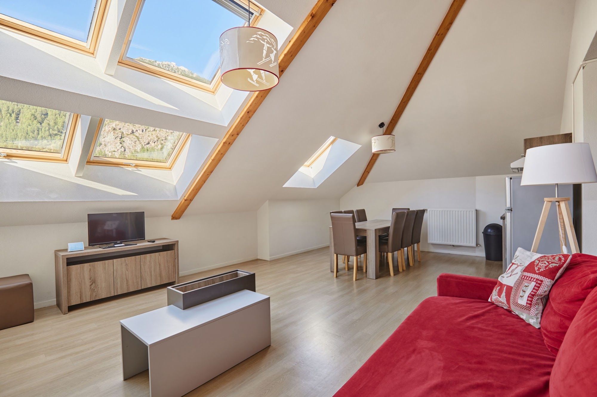 image Open-plan living area with dining table, TV and skylights