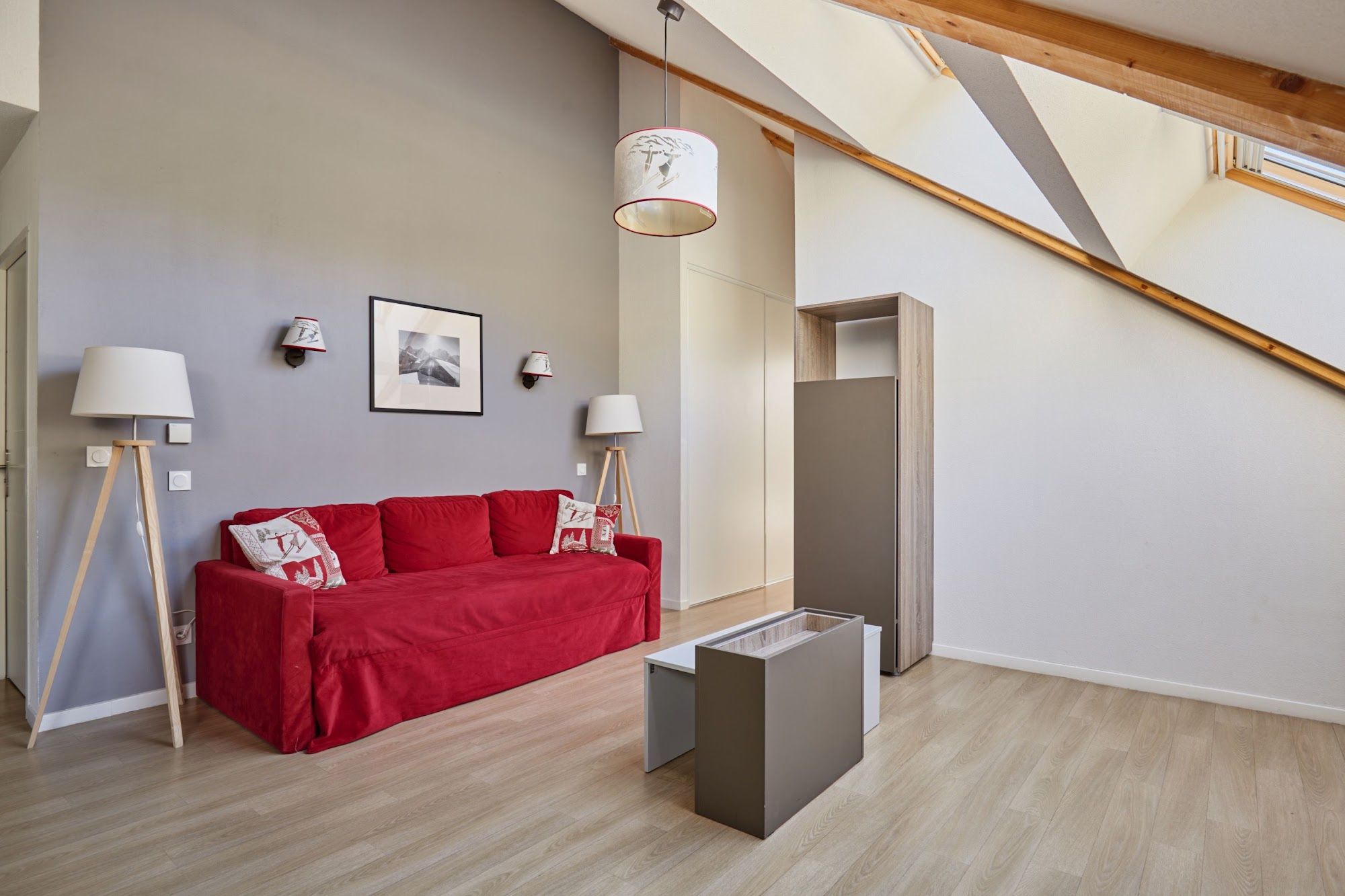 image Living room with a red sofa, coffee table and wall lights