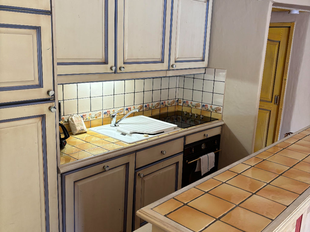image Fully equipped kitchen with ample counter space and traditional tiled finishes.