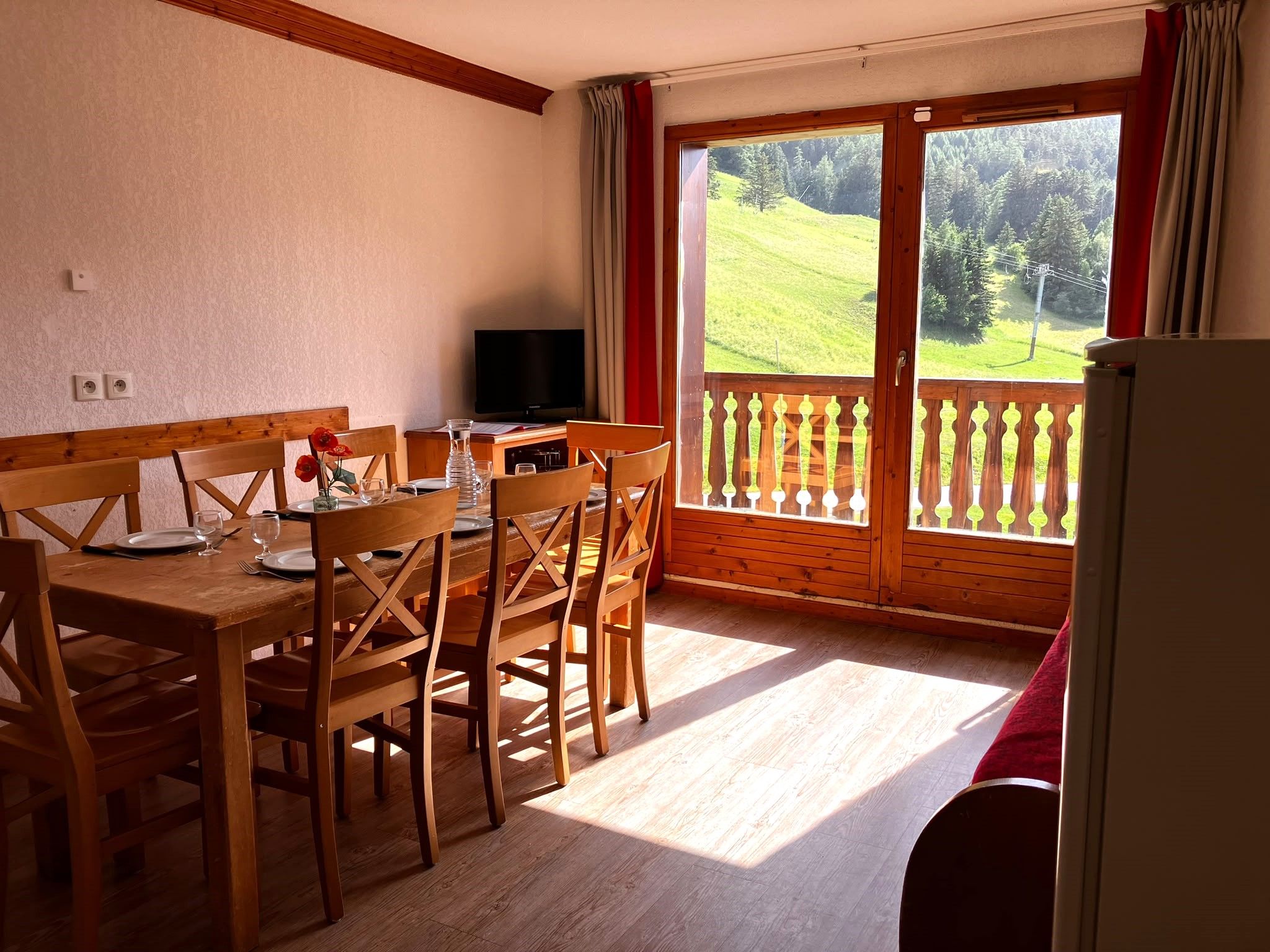 image Light spills through the balcony door onto the wooden dining table
