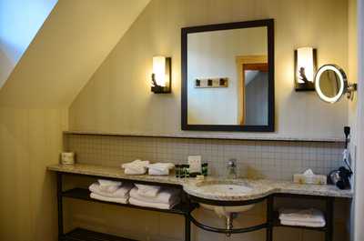 The modern and spacious bathroom features stylish decor and a deluxe Mountain Rain Shower.