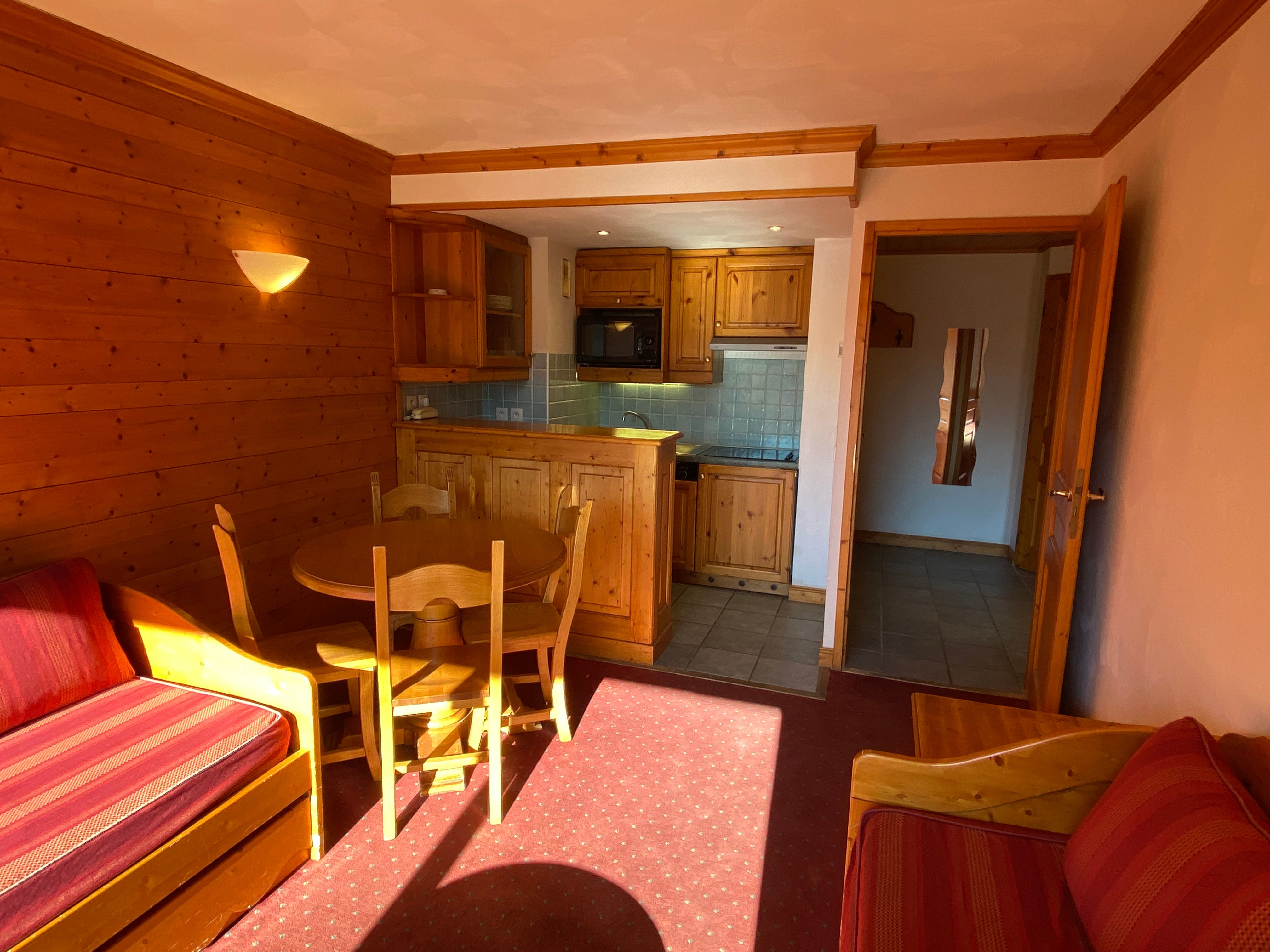 image Warm timber walls frame the round dining table, with the kitchenette just a few steps away.