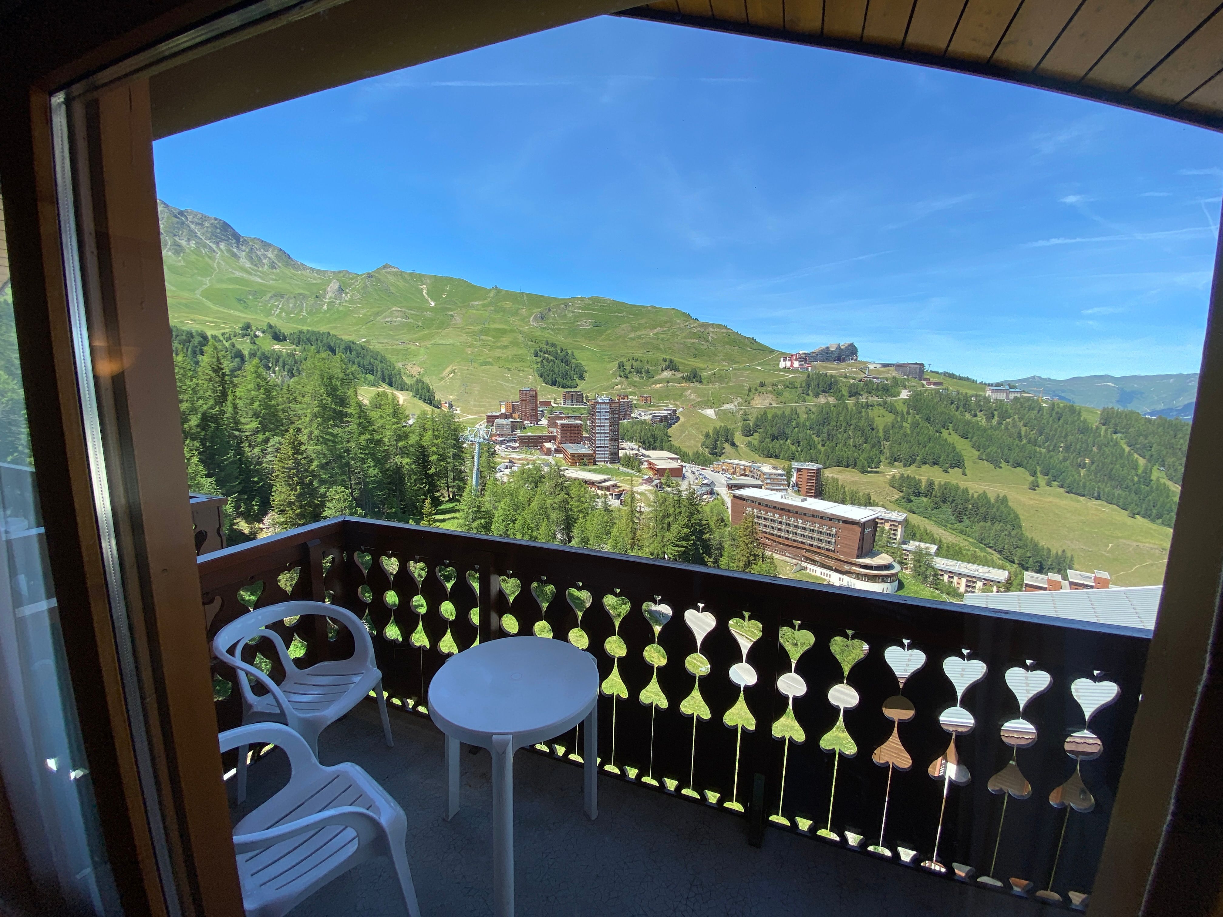 image Morning sun on the balcony, with the resort village and green mountainside spread out below.