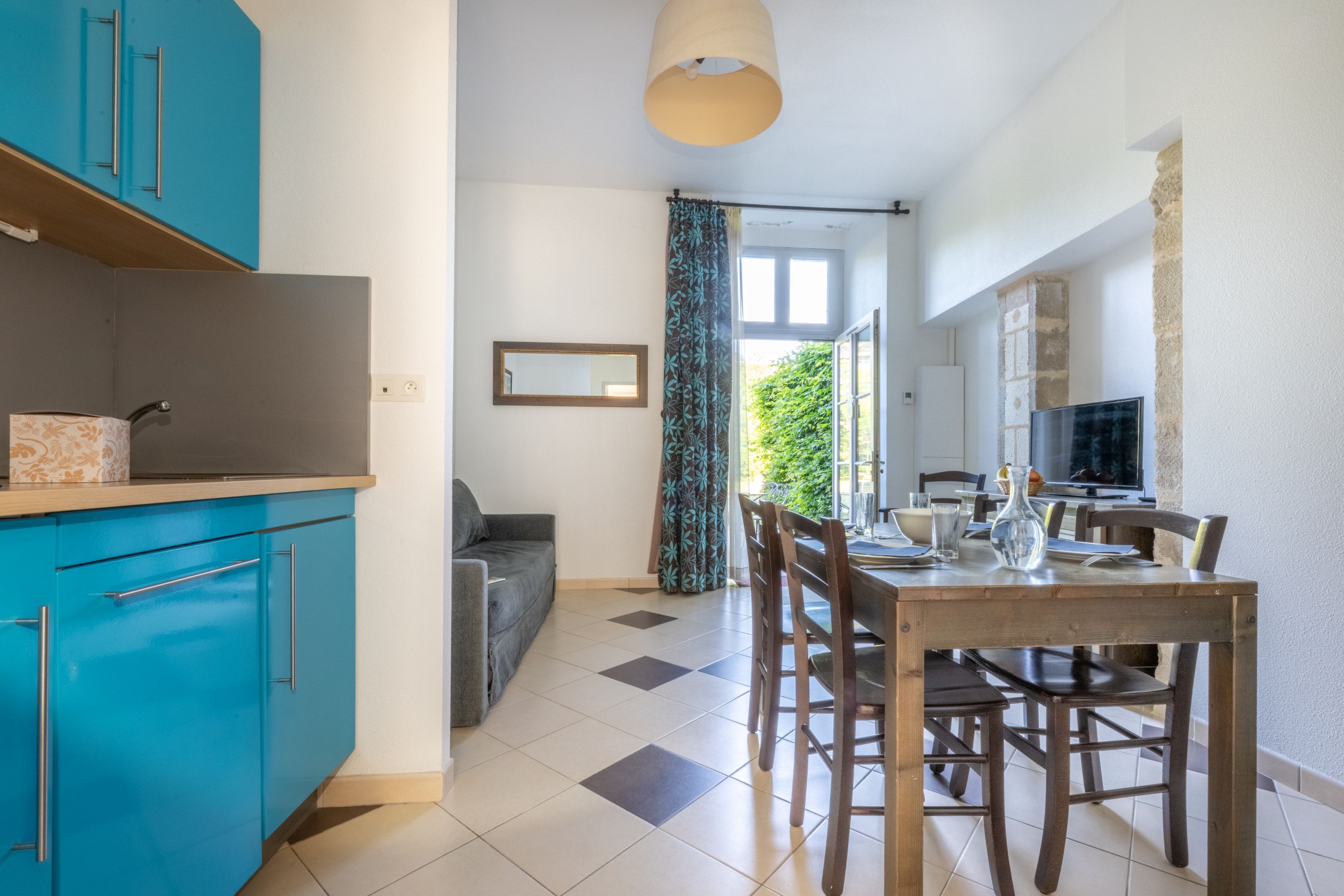 image Large windows bring natural light into the open living and dining area, next to the blue kitchen.