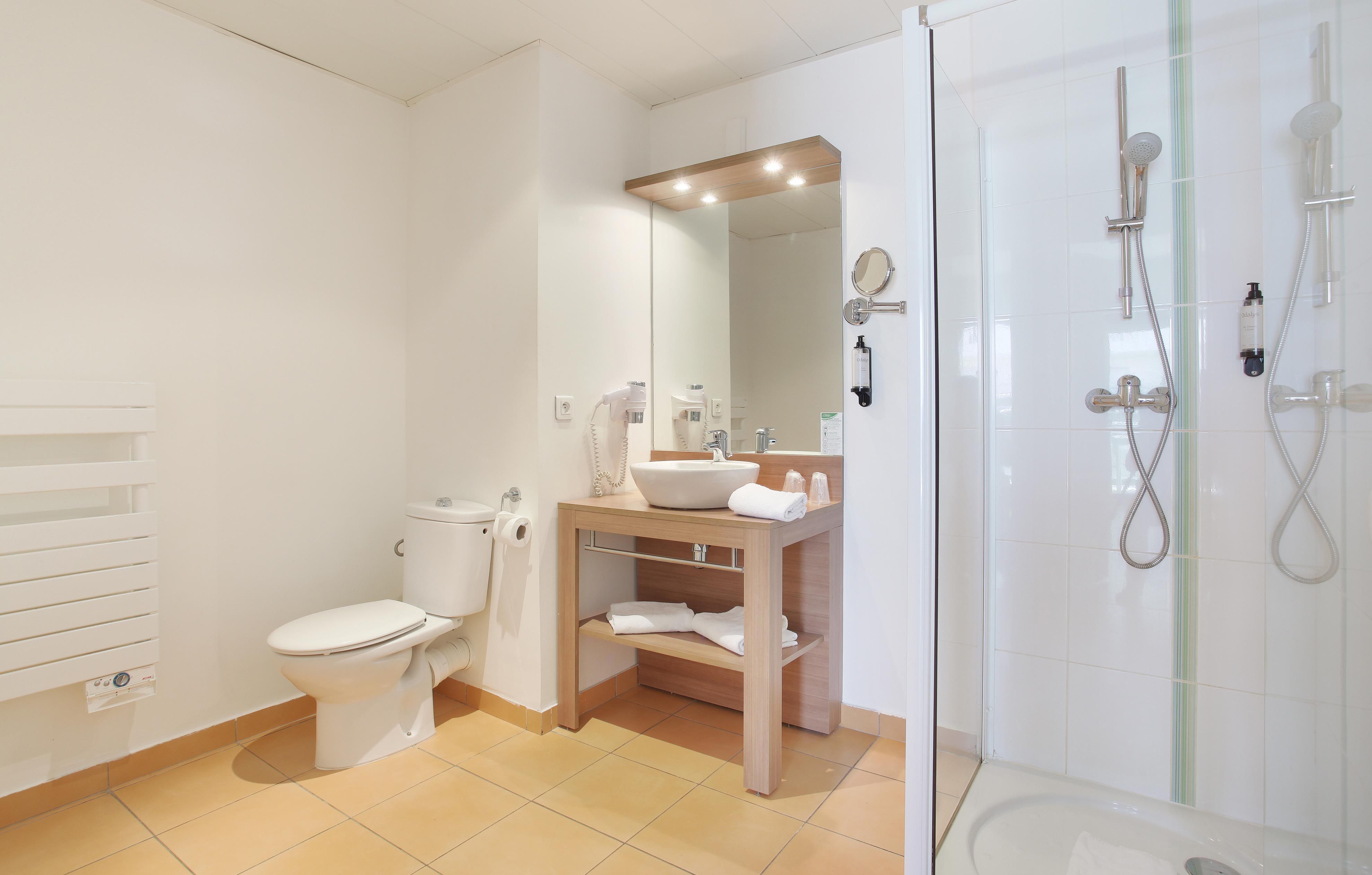 image Modern bathroom with walk-in shower, sleek vanity, and thoughtful touches for a comfortable stay.