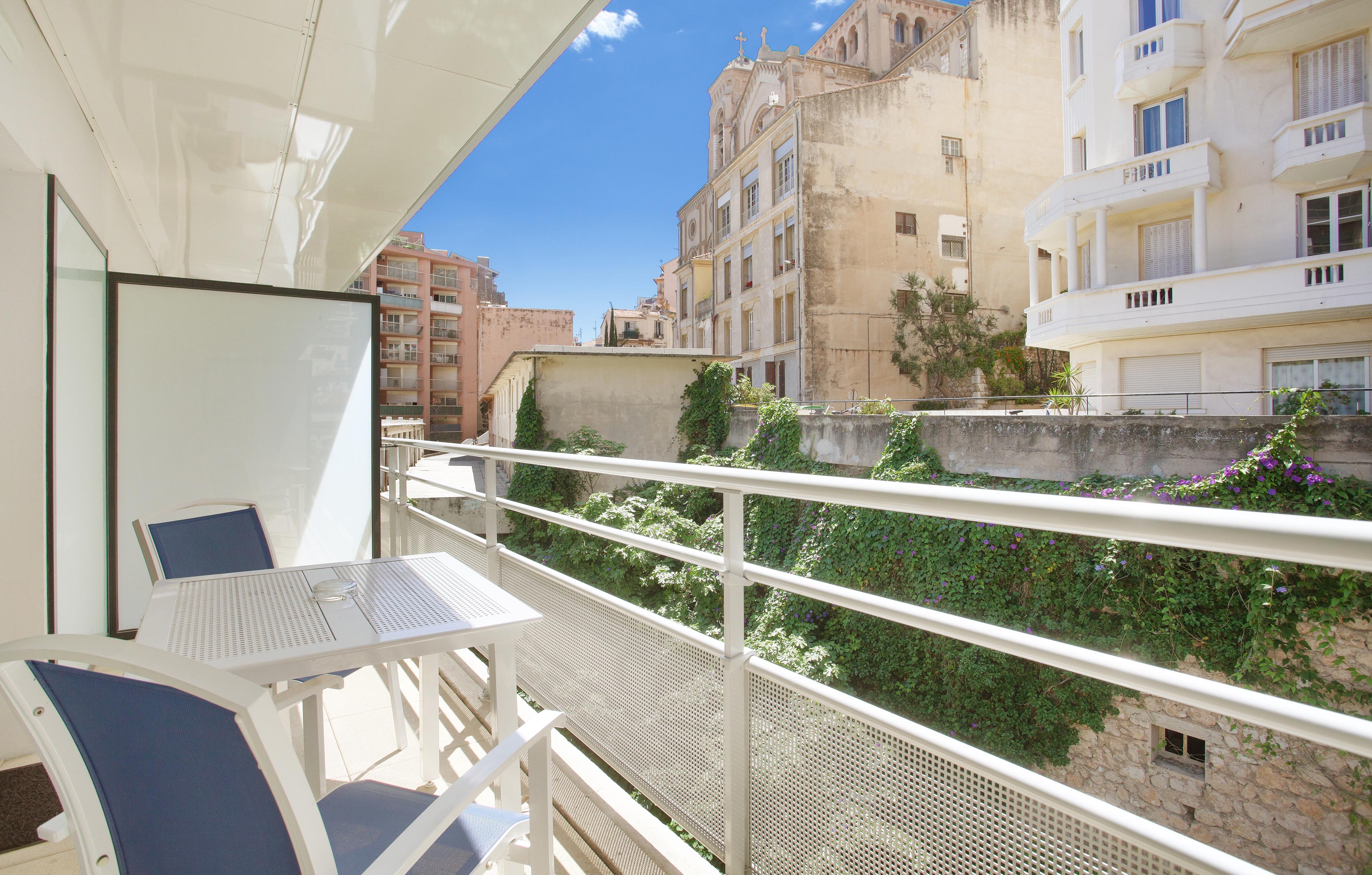 image Private balcony with table and chairs — enjoy a morning coffee with views of the surrounding Beausoleil charm.