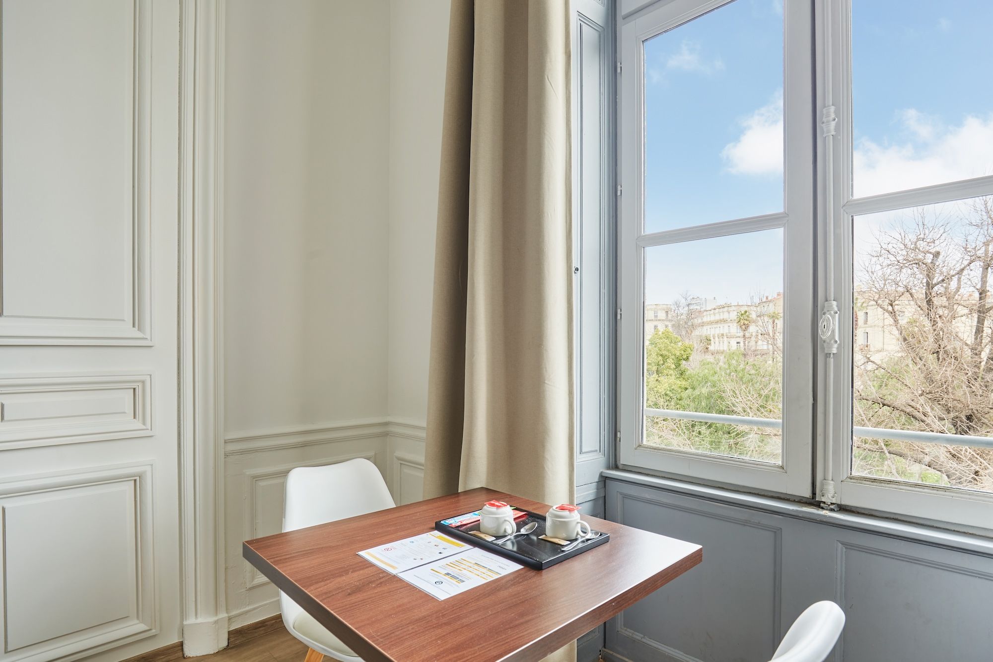 image A cozy work or reading space with natural daylight and views over Montpellier’s historic rooftops.