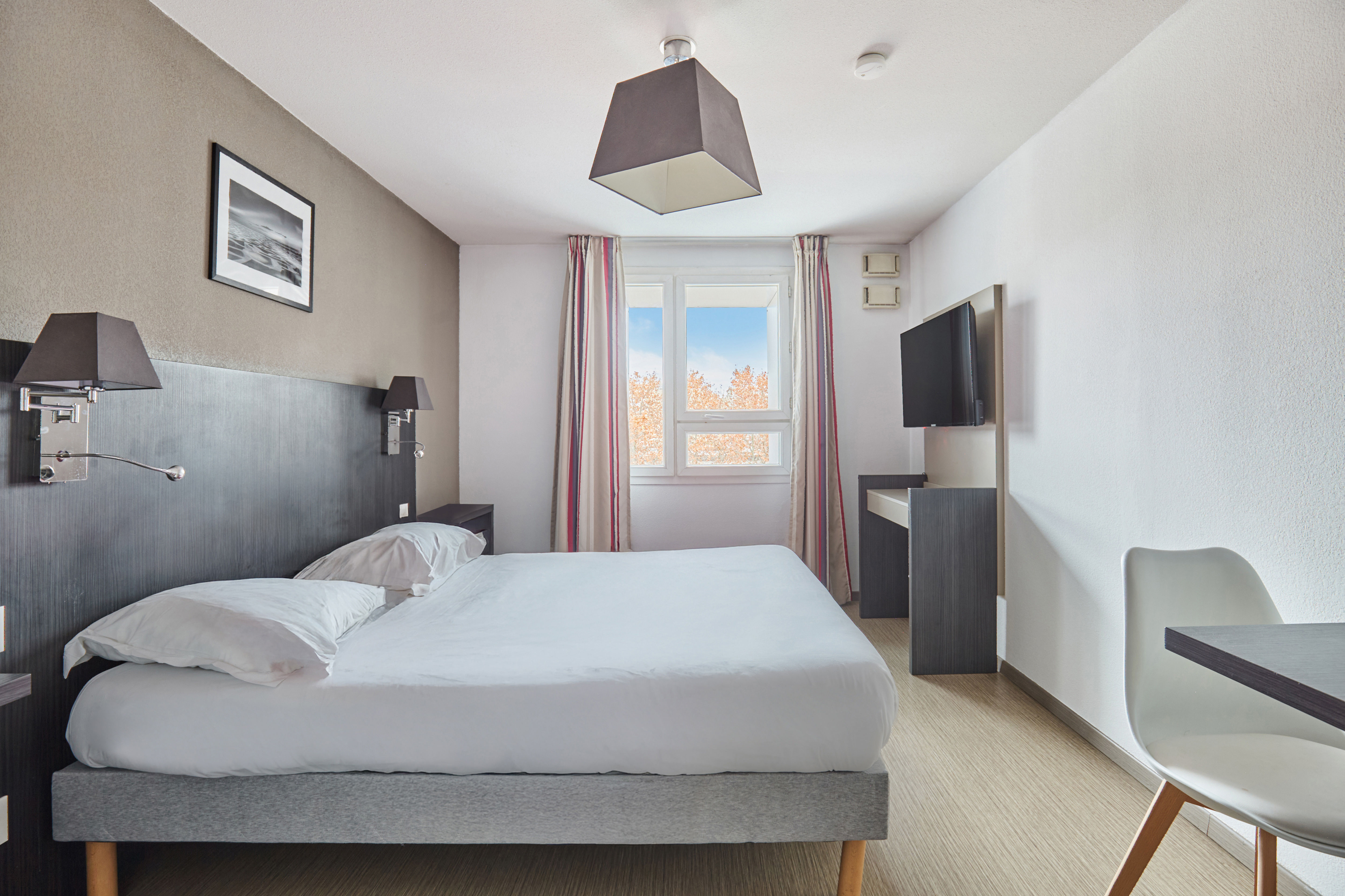 image Bright, stylish room filled with natural light and practical furnishings for a relaxing stay.