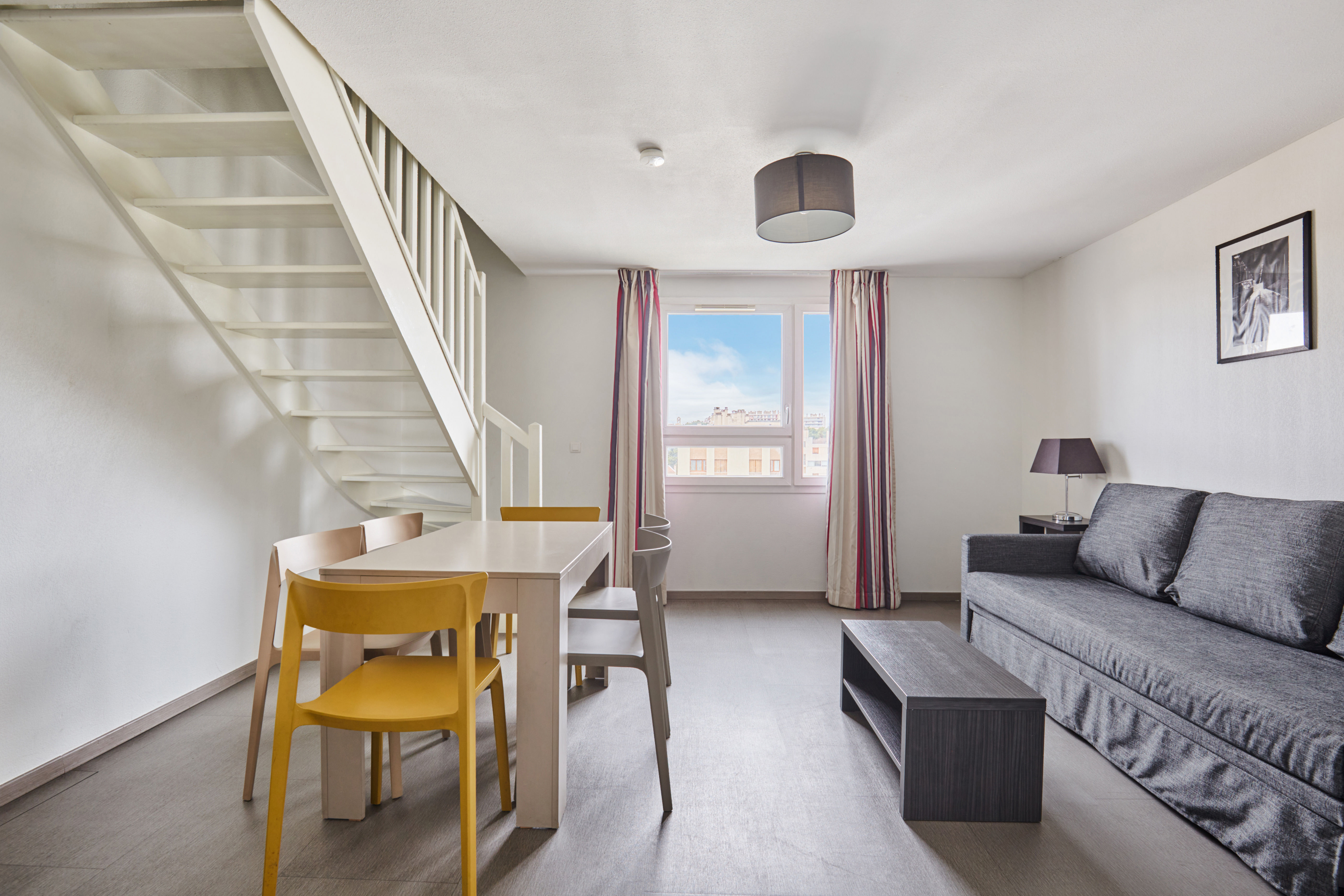 image Inviting living area with modern sofa and dining table creating a cozy space for family relaxation.