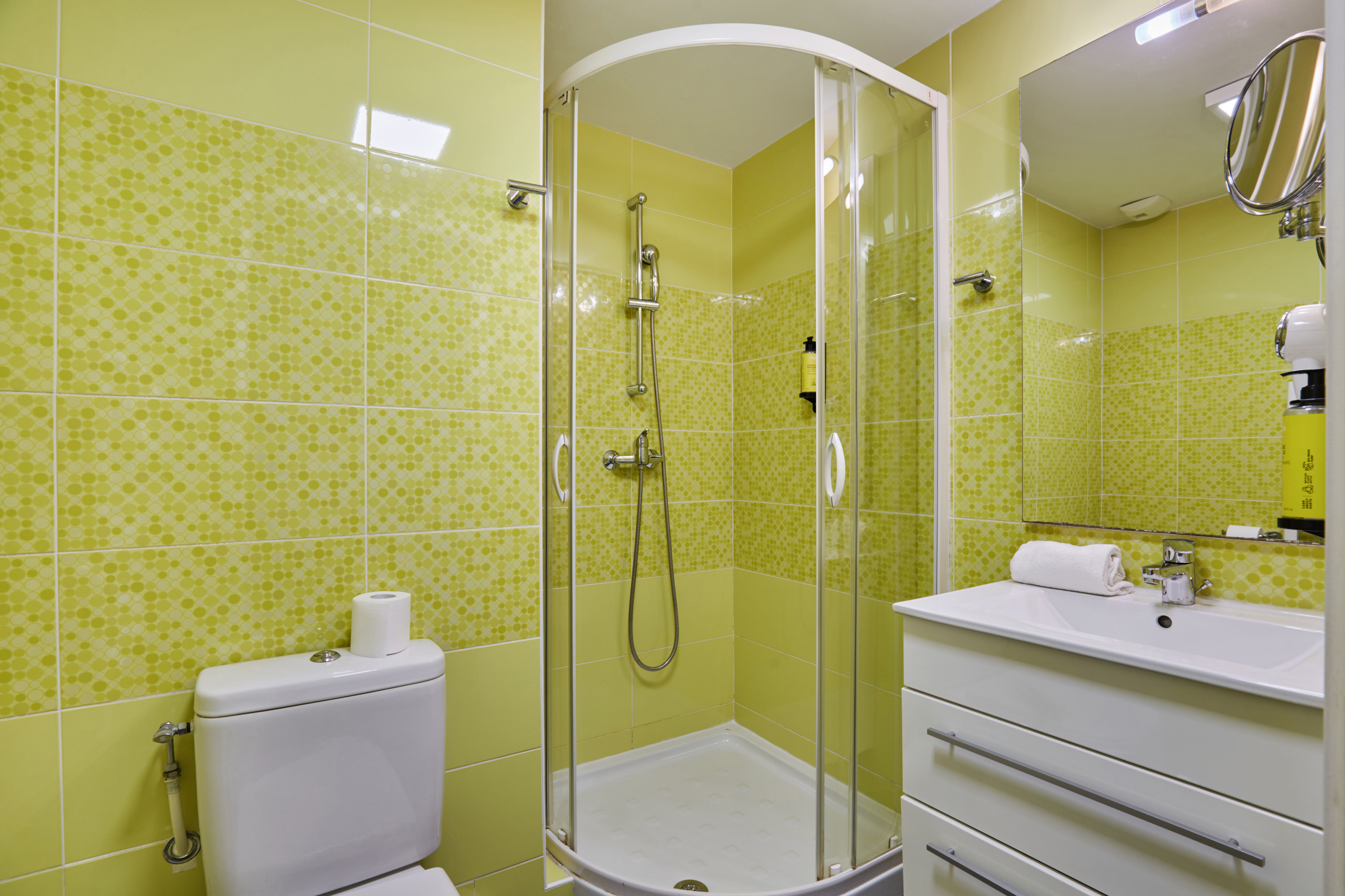 image Step into a refreshing bathroom adorned with vibrant tiles, featuring a spacious shower, ensuring you feel rejuvenated after each day.