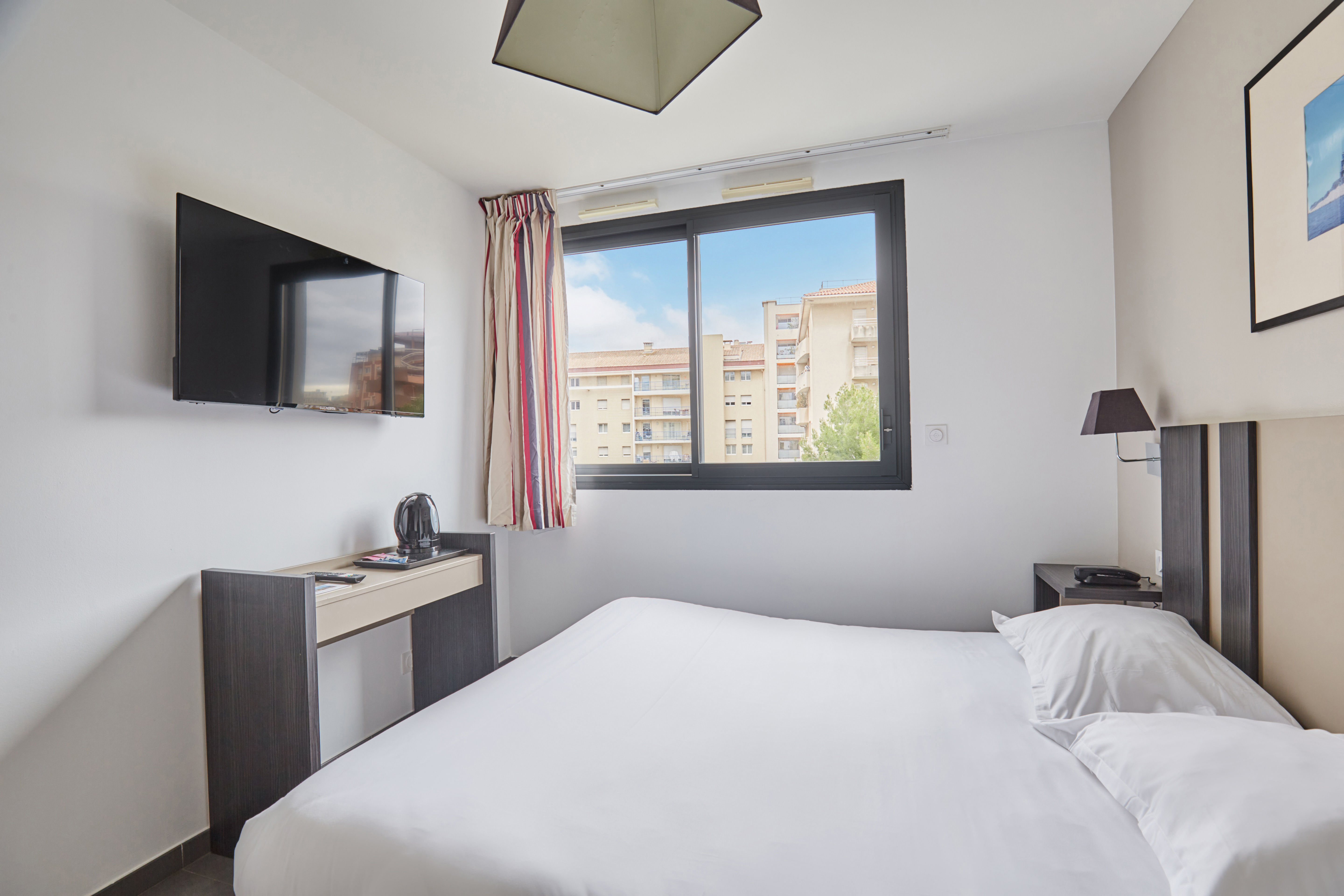 image Embrace relaxation in this bright studio equipped with a flat-screen TV, soft linens, and inviting ambiance for a perfect retreat.