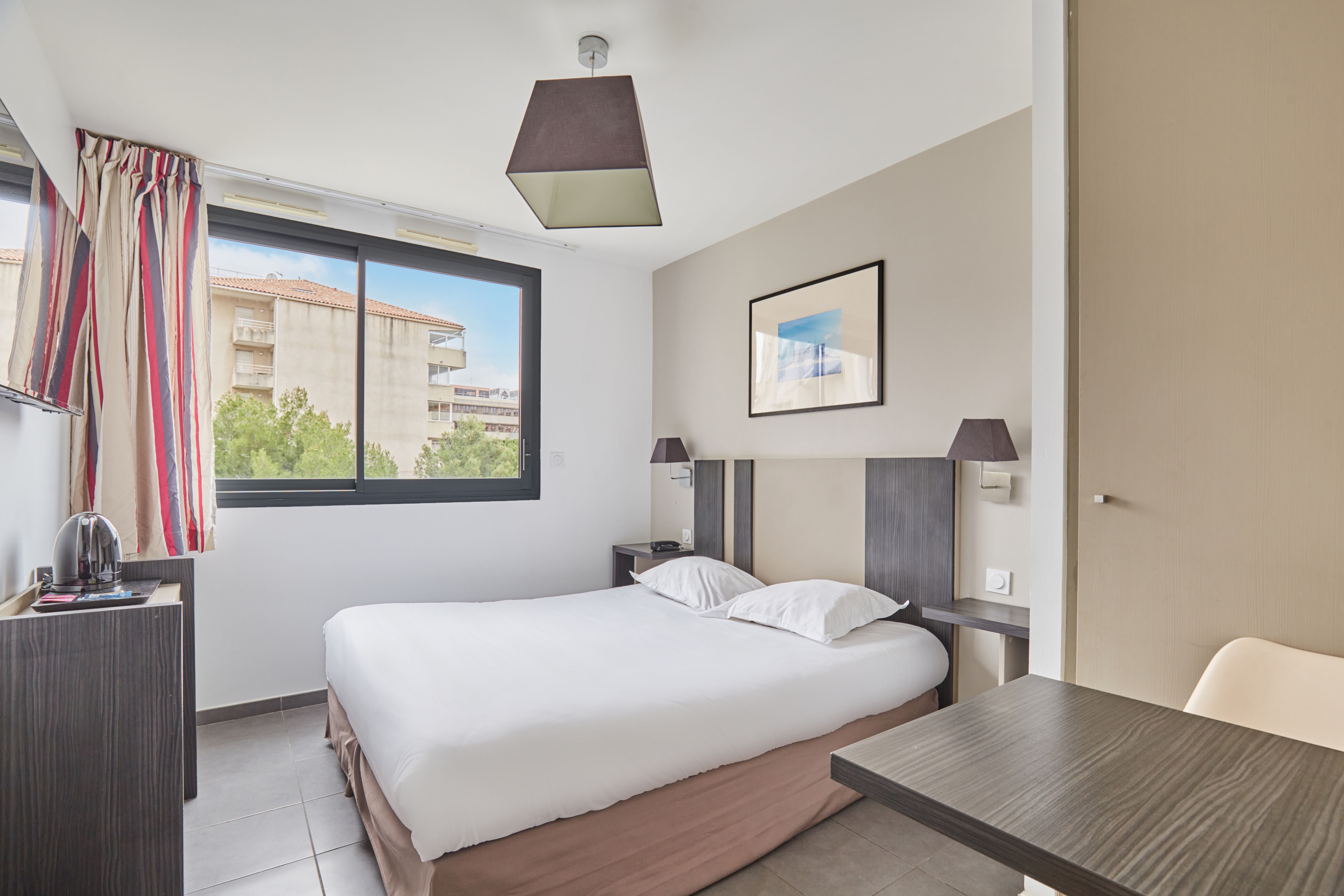 image This cozy studio features a modern bed, ample natural light from large windows, and stylish decor, perfect for a comfortable stay in Marseille.