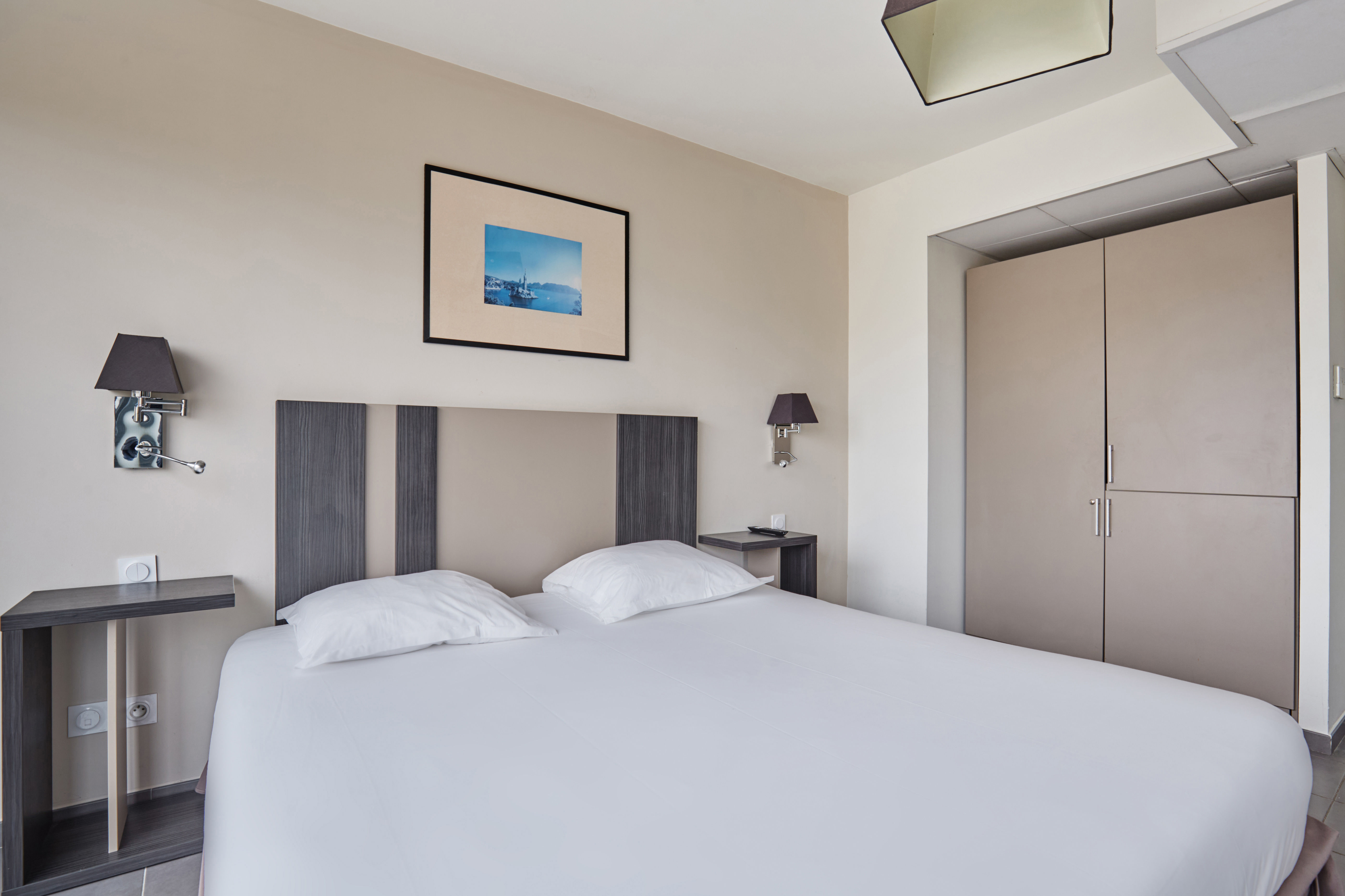 image This inviting bedroom offers a comfortable bed, sleek cabinetry, and warm tones, perfect for relaxing after a day of exploring the beautiful city.